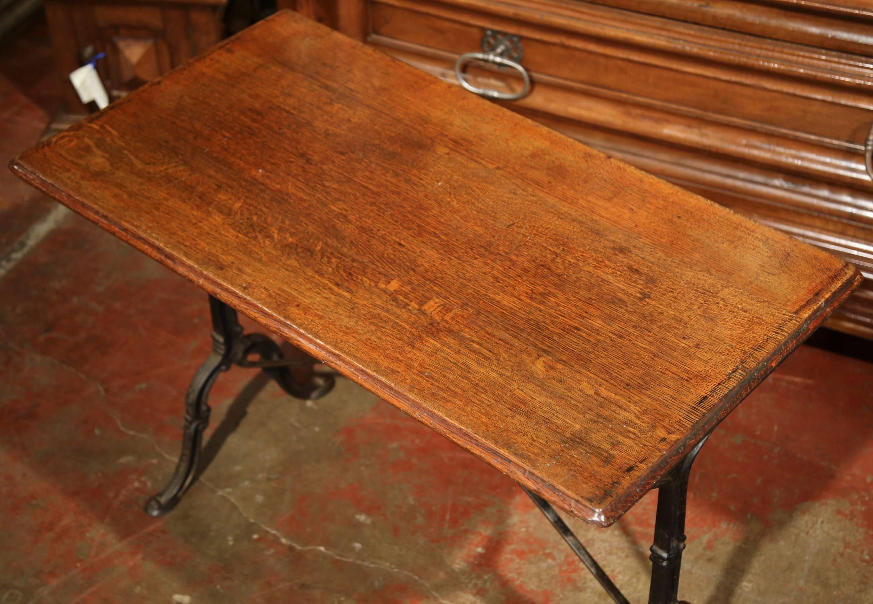This antique bistrot table would make the perfect addition to a small room or breakfast nook. Crafted in Paris, France, circa 1900, and used in bistrots, the table has an intricate cast iron base and stretcher, which is topped with a sturdy wooden