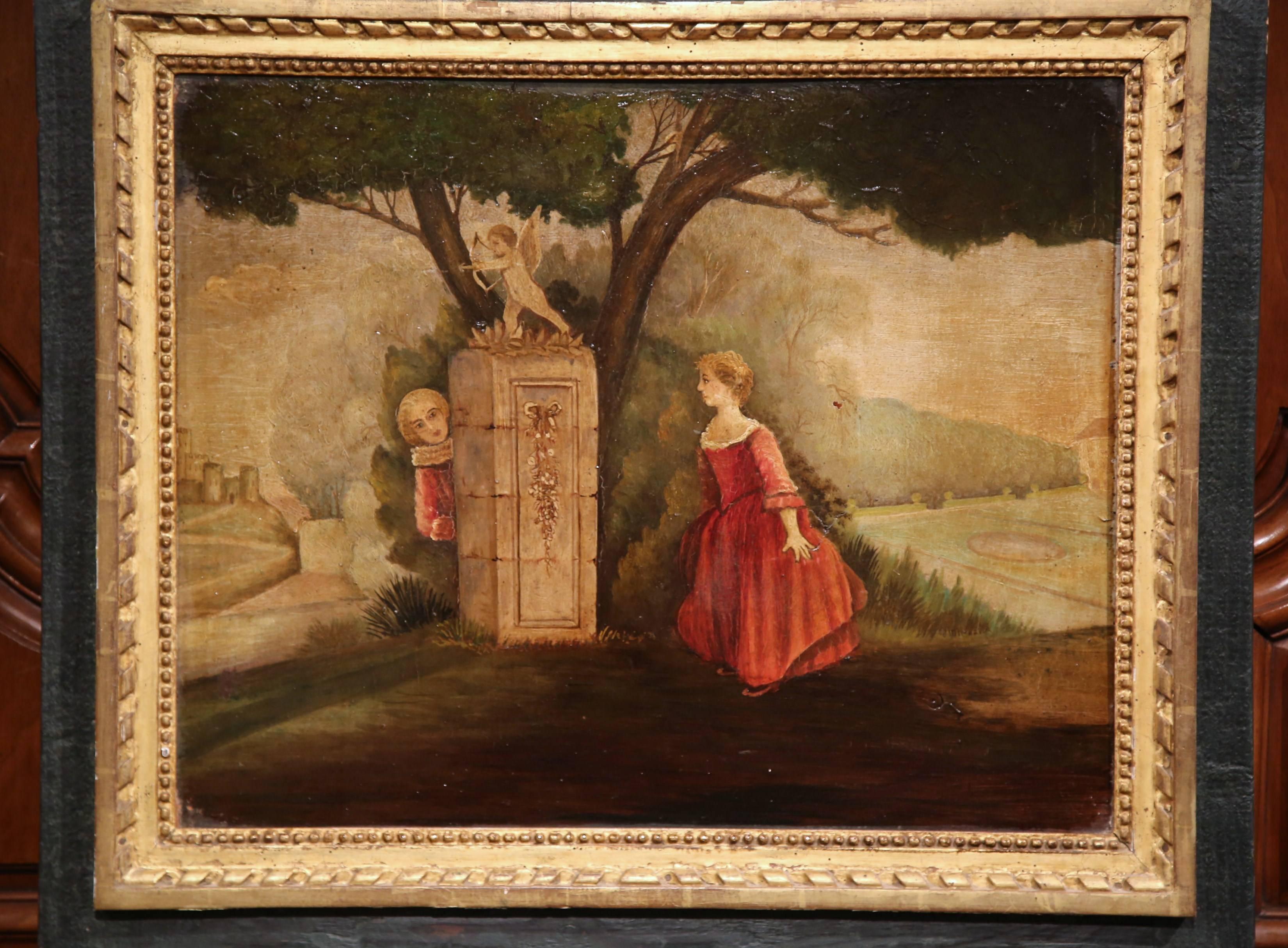 This elegant antique trumeau was created in France, circa 1840. The wall hanging decoration has two sections; a painting on canvas over a rectangular mirror. The bucolic scene depicts a gentleman and a woman playing hide and seek in a park; the