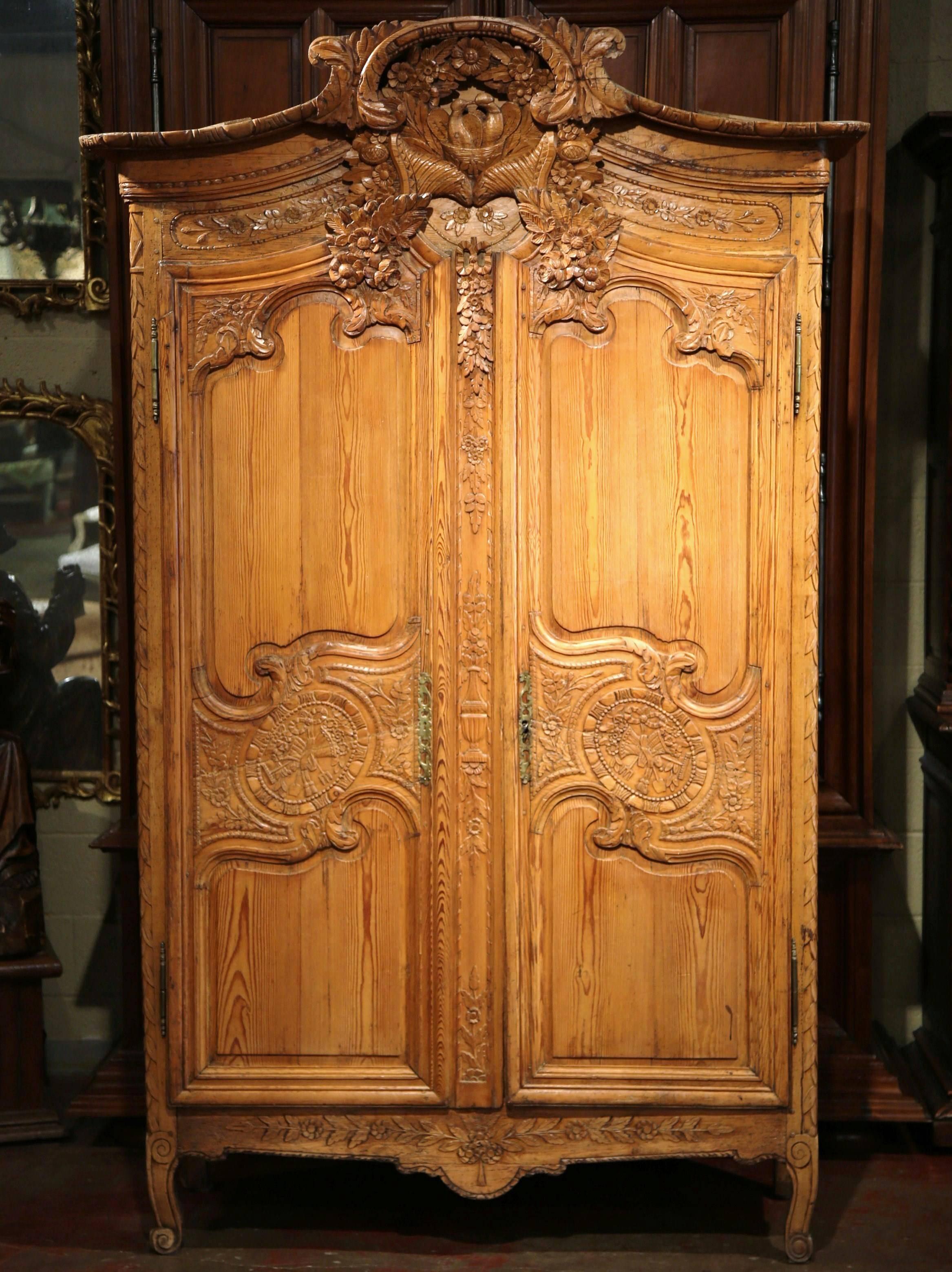 This elegant, antique armoire was crafted in Normandy, France, circa 1760. The pine cabinet with bonnet top and scroll feet, features all the elements of a traditional wedding armoire. (In the past, a wedding armoire was a gift to the bride from the