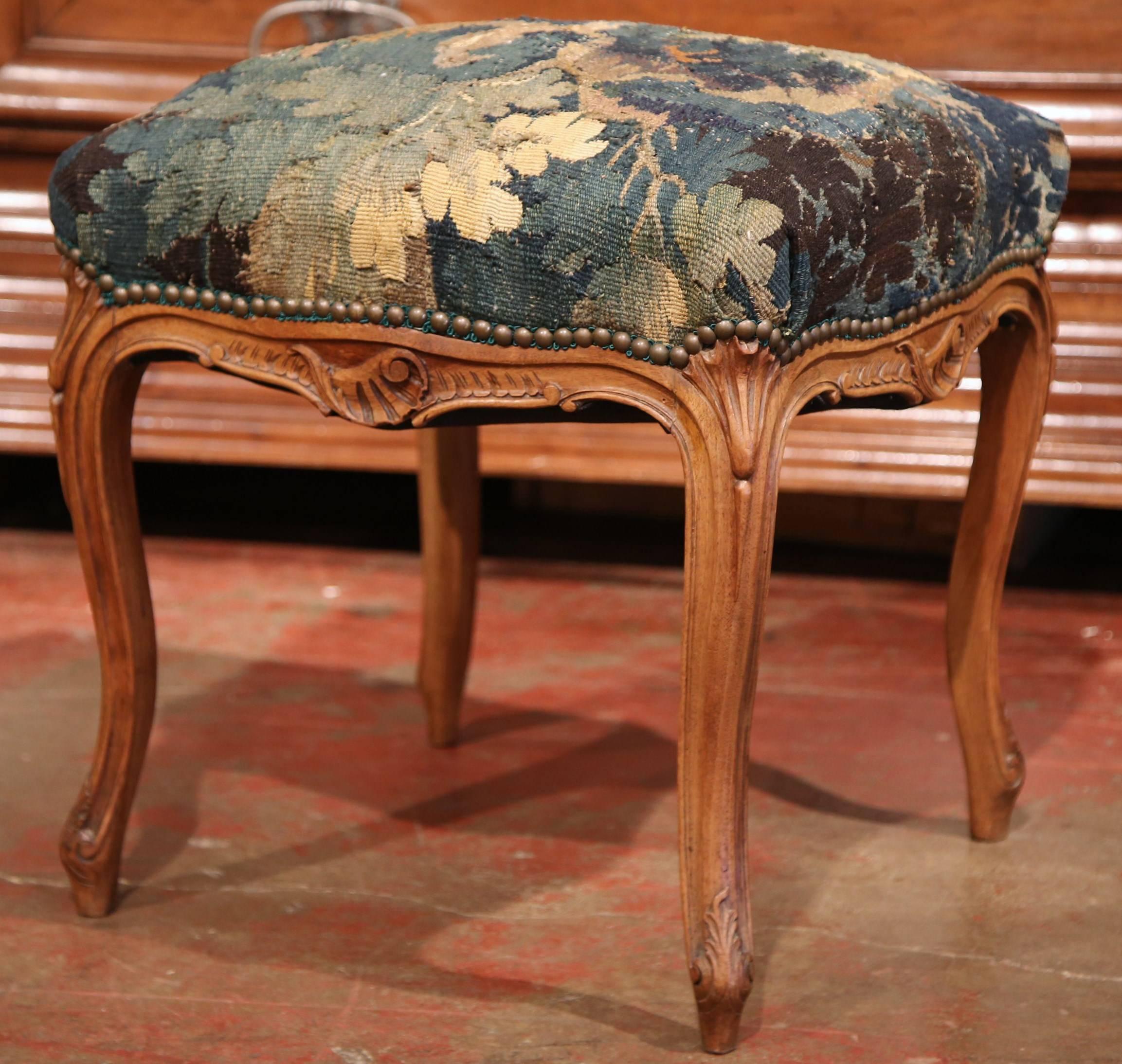 This elegant, carved fruitwood stool was crafted in Provence, France, circa 1890. The square stool has four cabriole legs and a wooden frame embellished with detailed leaves and shells carvings. The stool cushion has been reupholstered with an