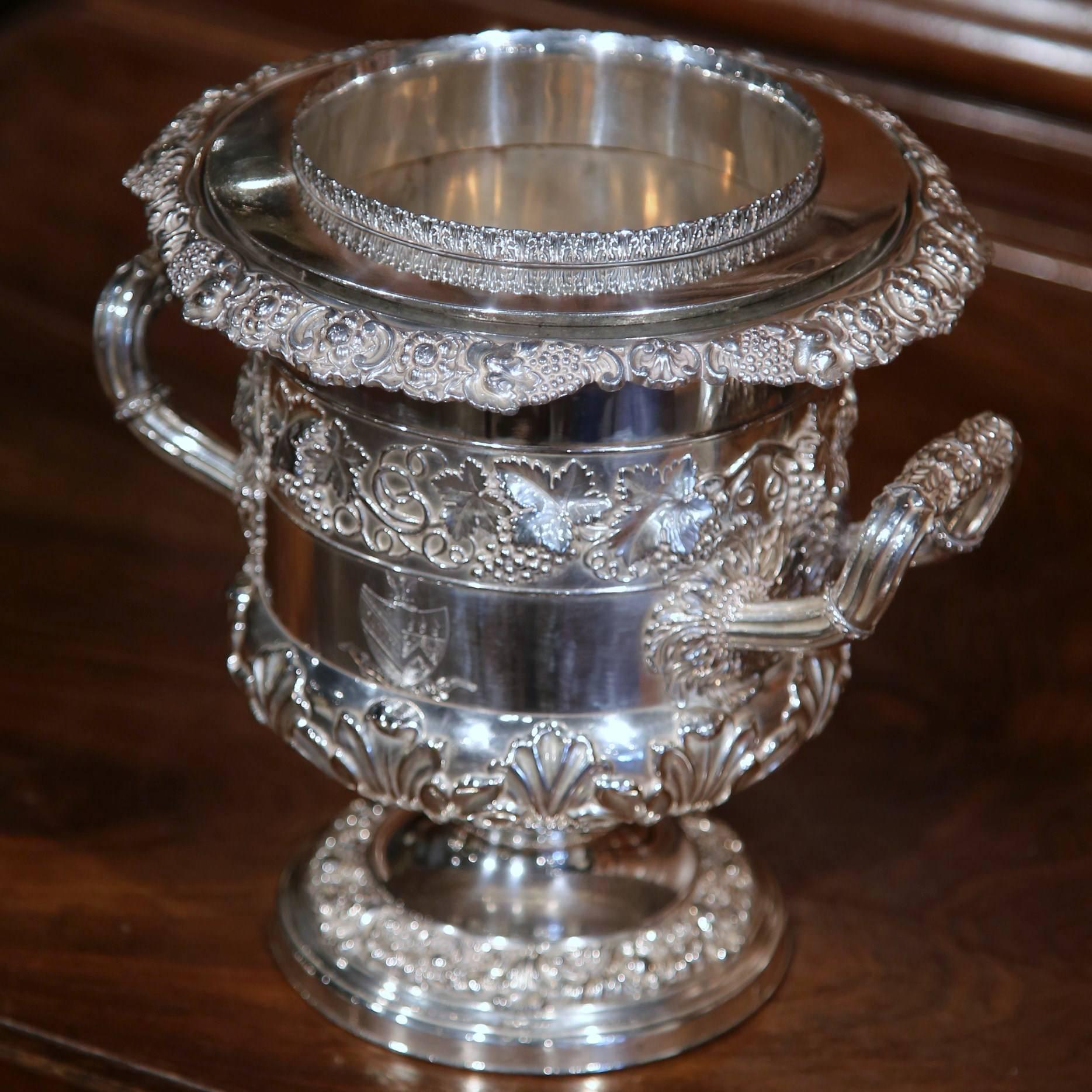 This beautifully carved silver plated champagne cooler was crafted in England, circa 1900. The wine holder is decorated with repousse designs, including grapes, vine leaves and flowers. Around the sides, the bucket is further embellished with two