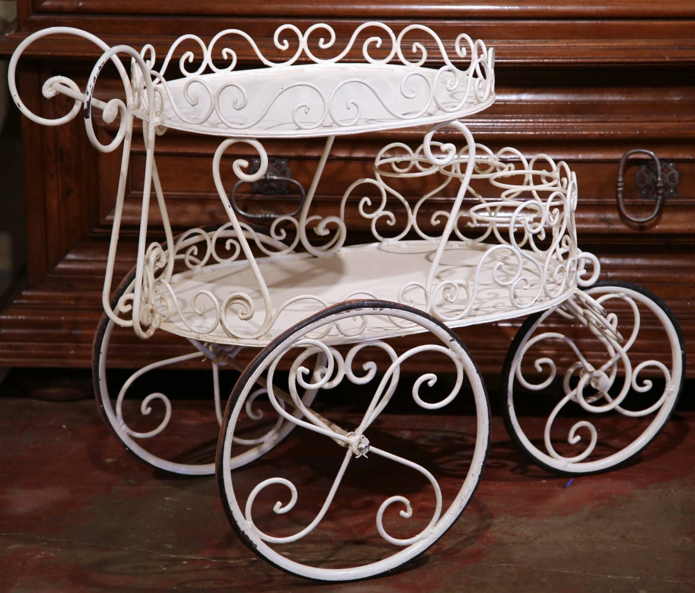 This elegant three-wheel cart was crafted in western France, circa 1920. The antique white iron cart stands on three wheels with rubber tires and features two levels; the top plateau with an ornate handle, has a decorative gallery around the