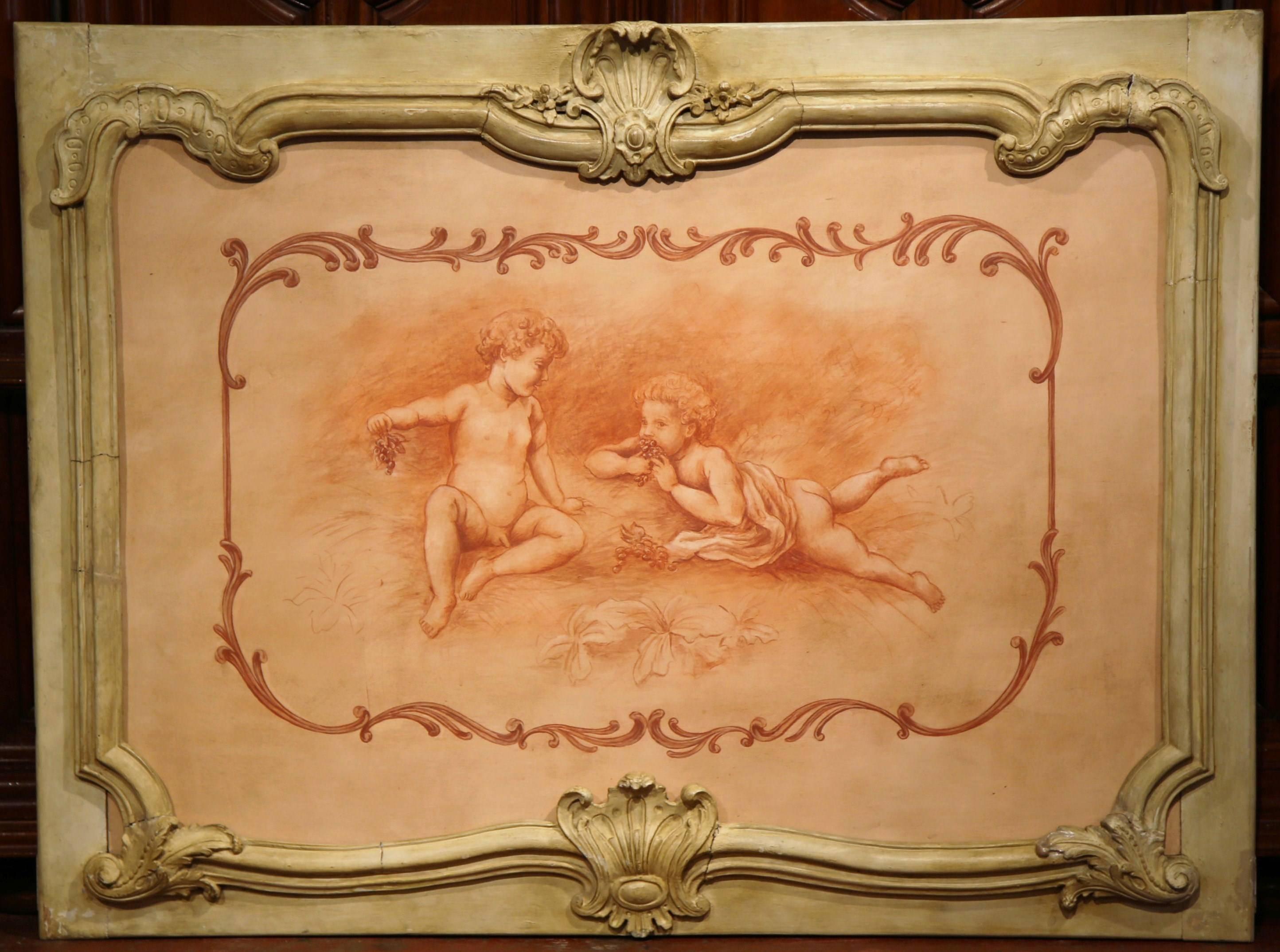 This elegant wall hanging wood panel came from a Parisian paneled room. The large painted frame was crafted in France, circa 1880, and depicts two cherubs at play eating grapes; the traditional, figural piece has wonderful hand-carved scrolled