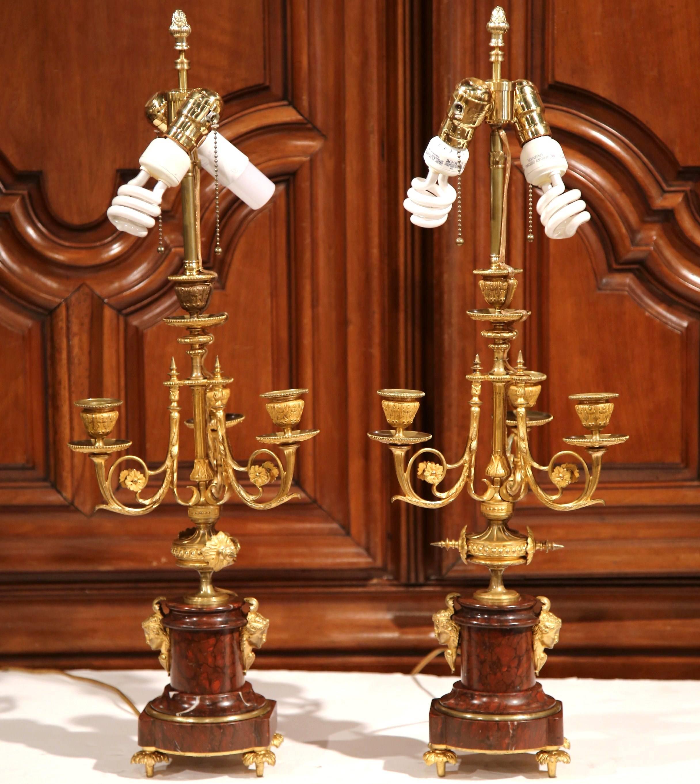 This large pair of Napoleon III antique candelabra was created in France, circa 1880. Each of the three-light bronze candelabras has a red marble base, which has been mounted into elegant lamps. The table lamps feature women's faces mounted on the