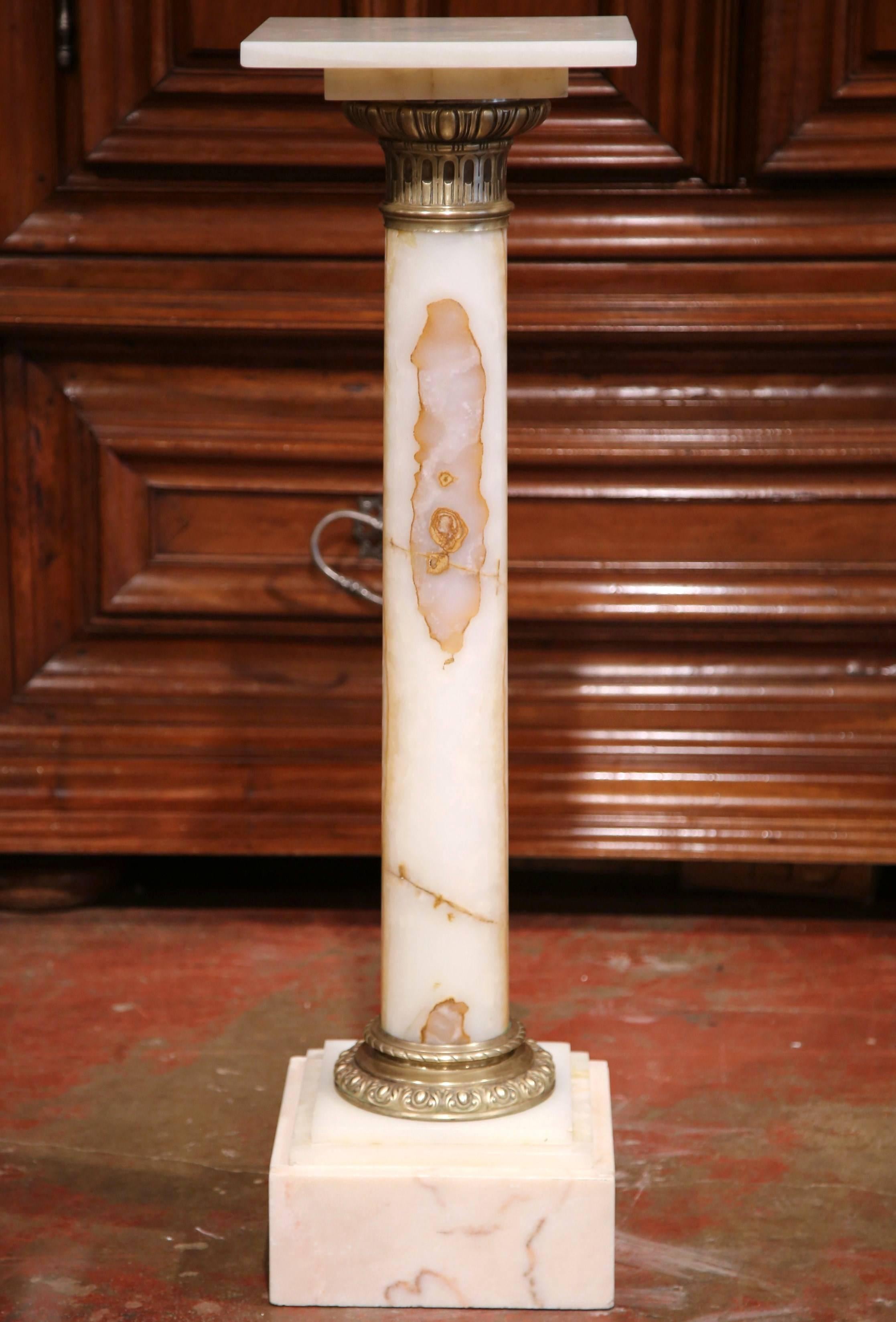 This elegant antique white marble pedestal was crafted in France, circa 1870. The pedestal features a sturdy square base with a repousse brass ring and a square surface with ornate brass mounts. Place this Classic, column pedestal in the corner of a