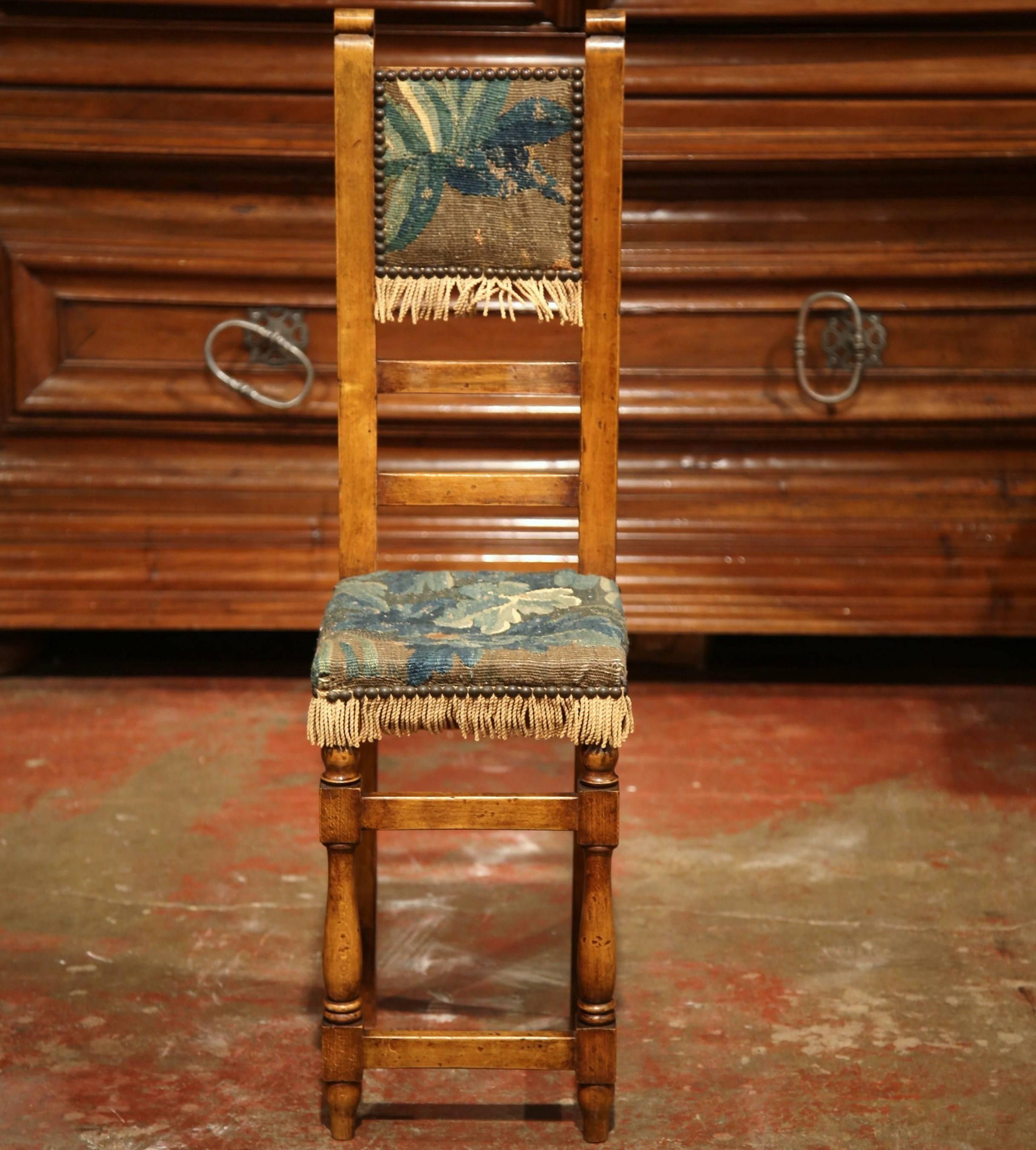 This beautiful, antique children's chair was created in France, circa 1760. The small fruitwood child sized chair features hand carved turned legs, and is upholstered with the original verdure Aubusson tapestry in a soft blue and green palette, with