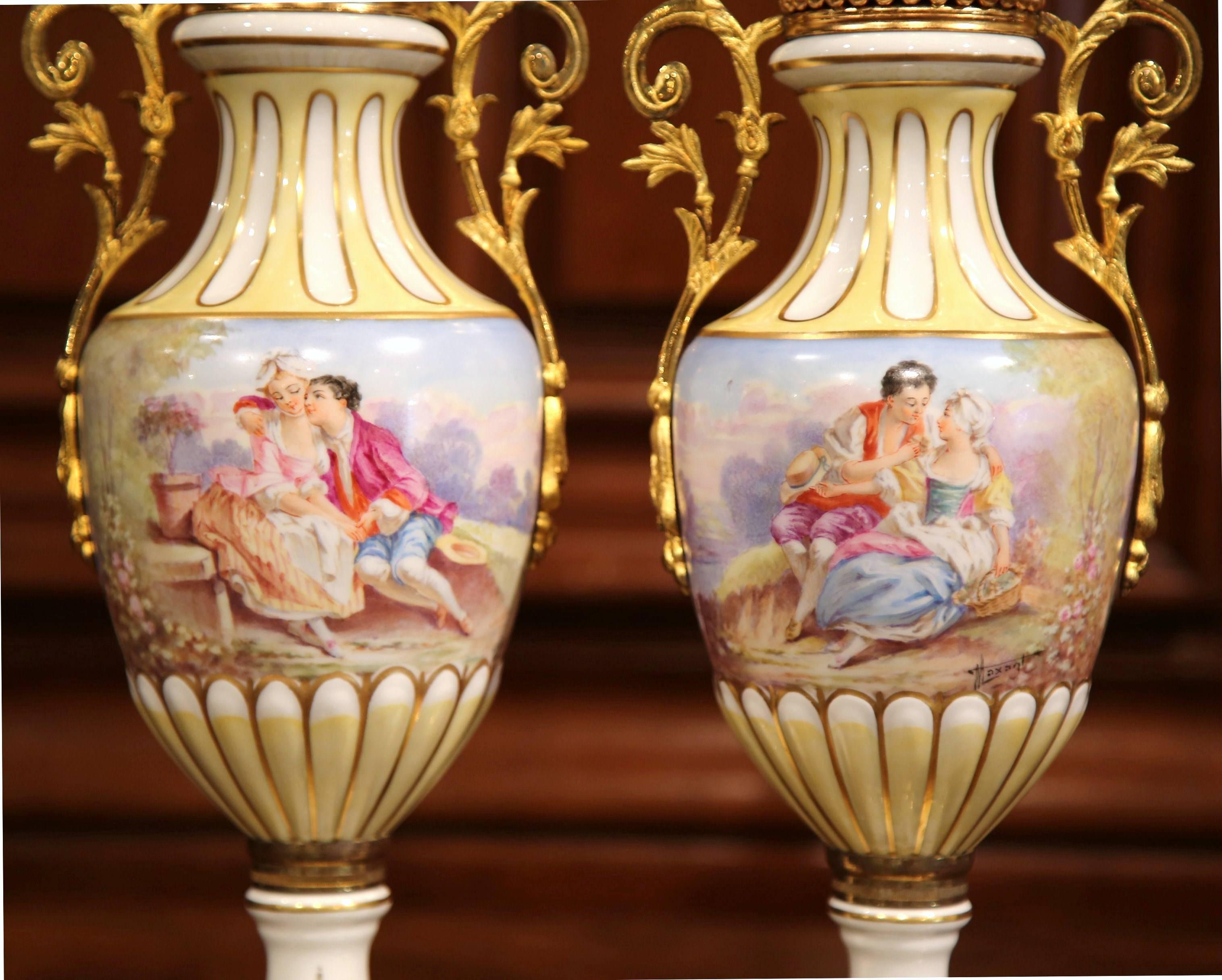 Pair of antique colorful vases from Sevres, France, circa 1890; the pair of hand painted urns with bronze mounts and handles, depicts a courting scene with wonderful colors. The vases are signed Maxant with a stamp "France" at the bottom.