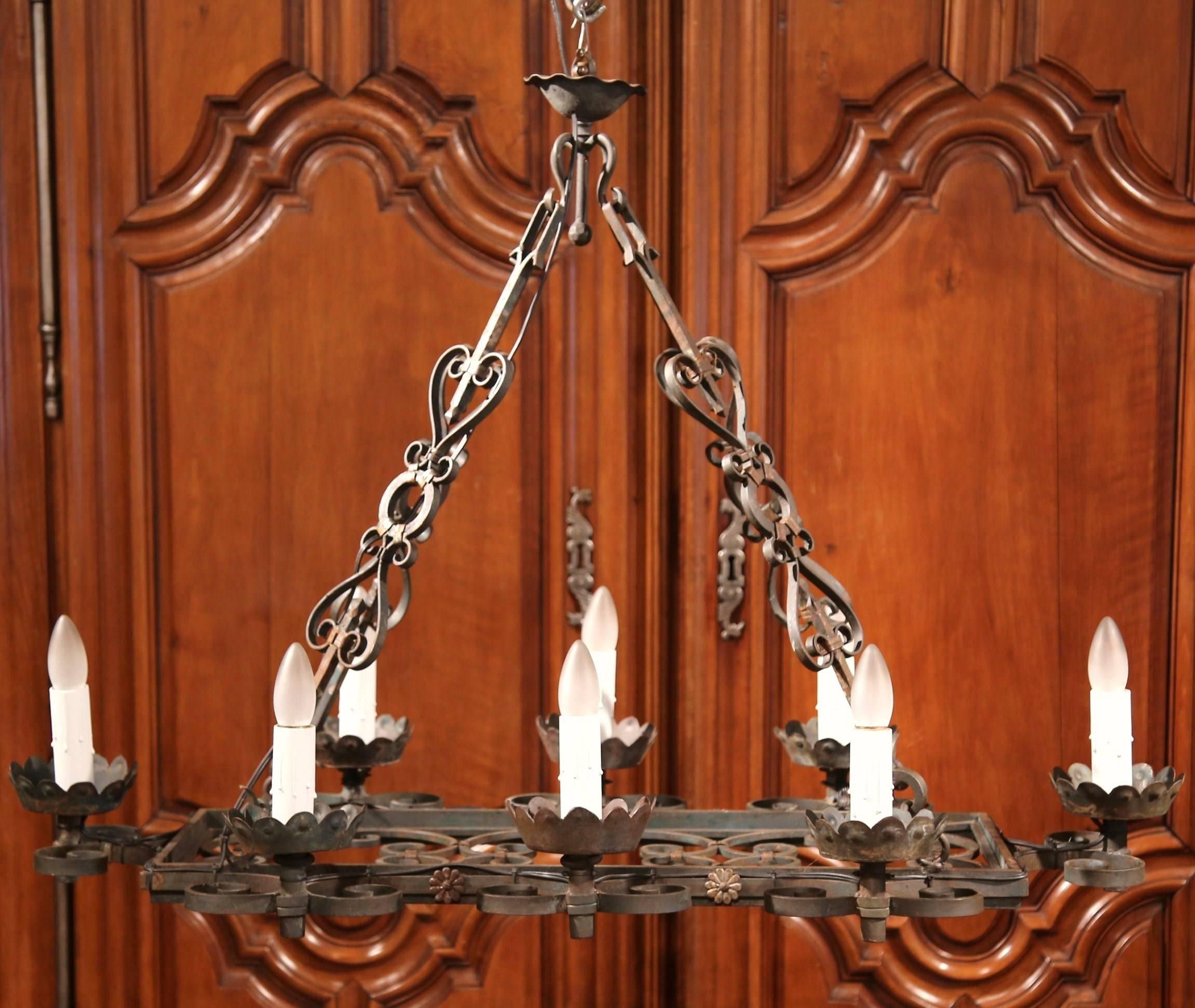 This elegant, antique light fixture was crafted in France, circa 1890. The ornate chandelier has eight lights and features an interesting rectangular flat bottom with scrolled iron work, and four chains with intricate scrolls. The statement