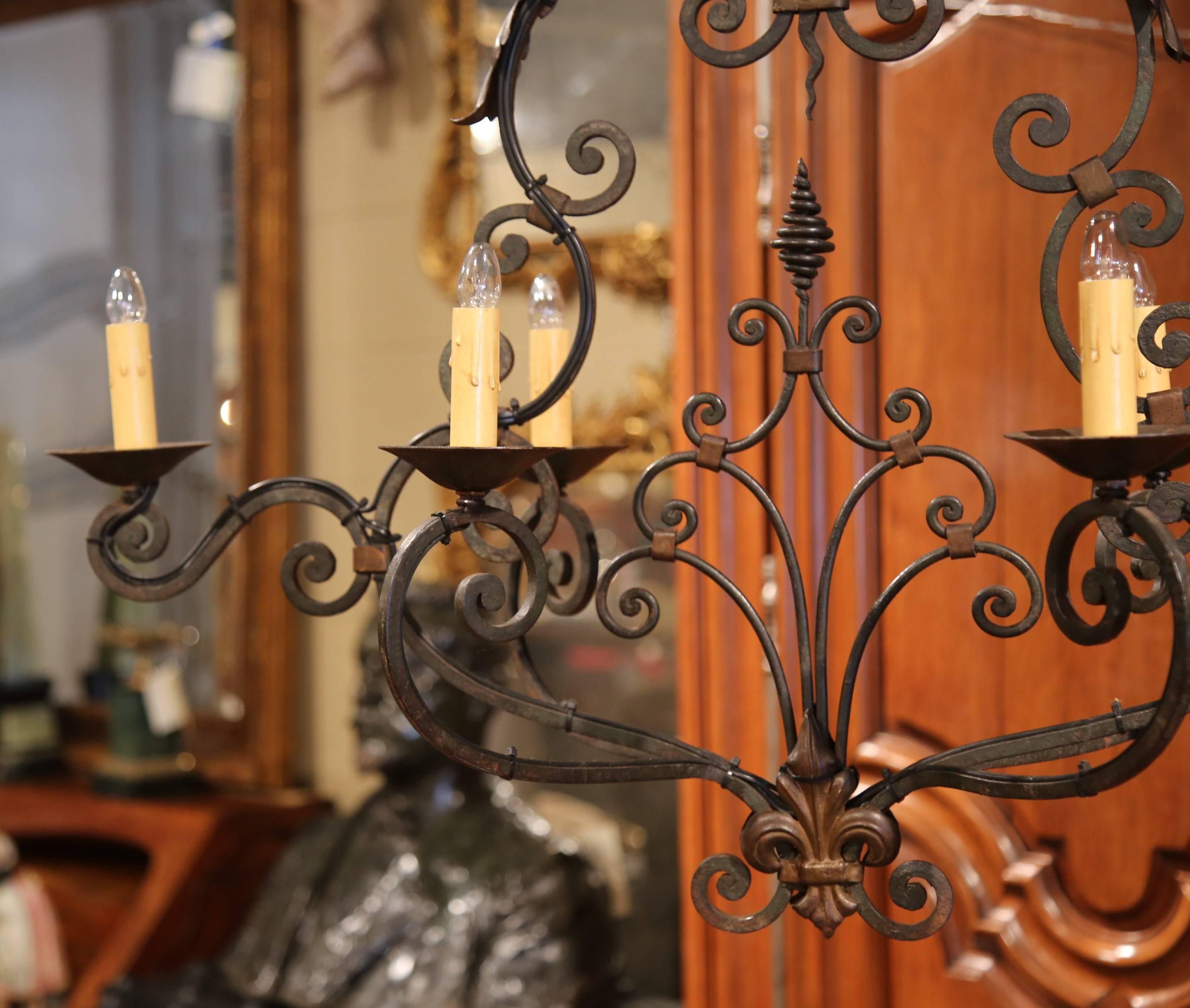 This elegant, scrolling, oblong chandelier would make a lovely addition to a home of any style. Crafted from iron, the chandelier was made in France, circa 1900. The light, expressive chandelier features six scrolled arms with metal leaves, curling