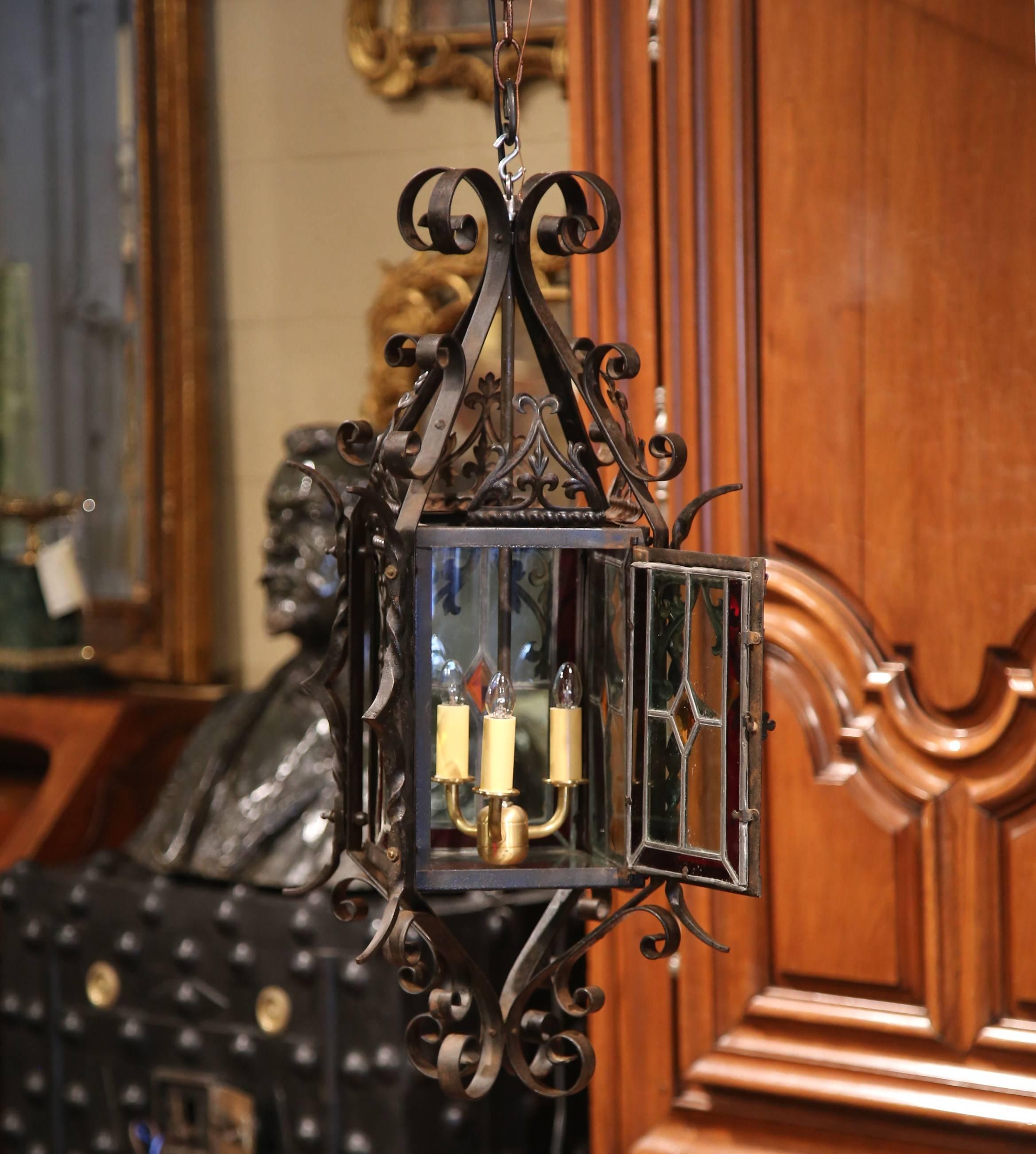 For a unique lighting feature, look no further than this elegant antique lantern; crafted circa 1870, the three-light chandelier features four painted, stained glass panels embellished with fleurs-de-lys, and a small door to access the inside light