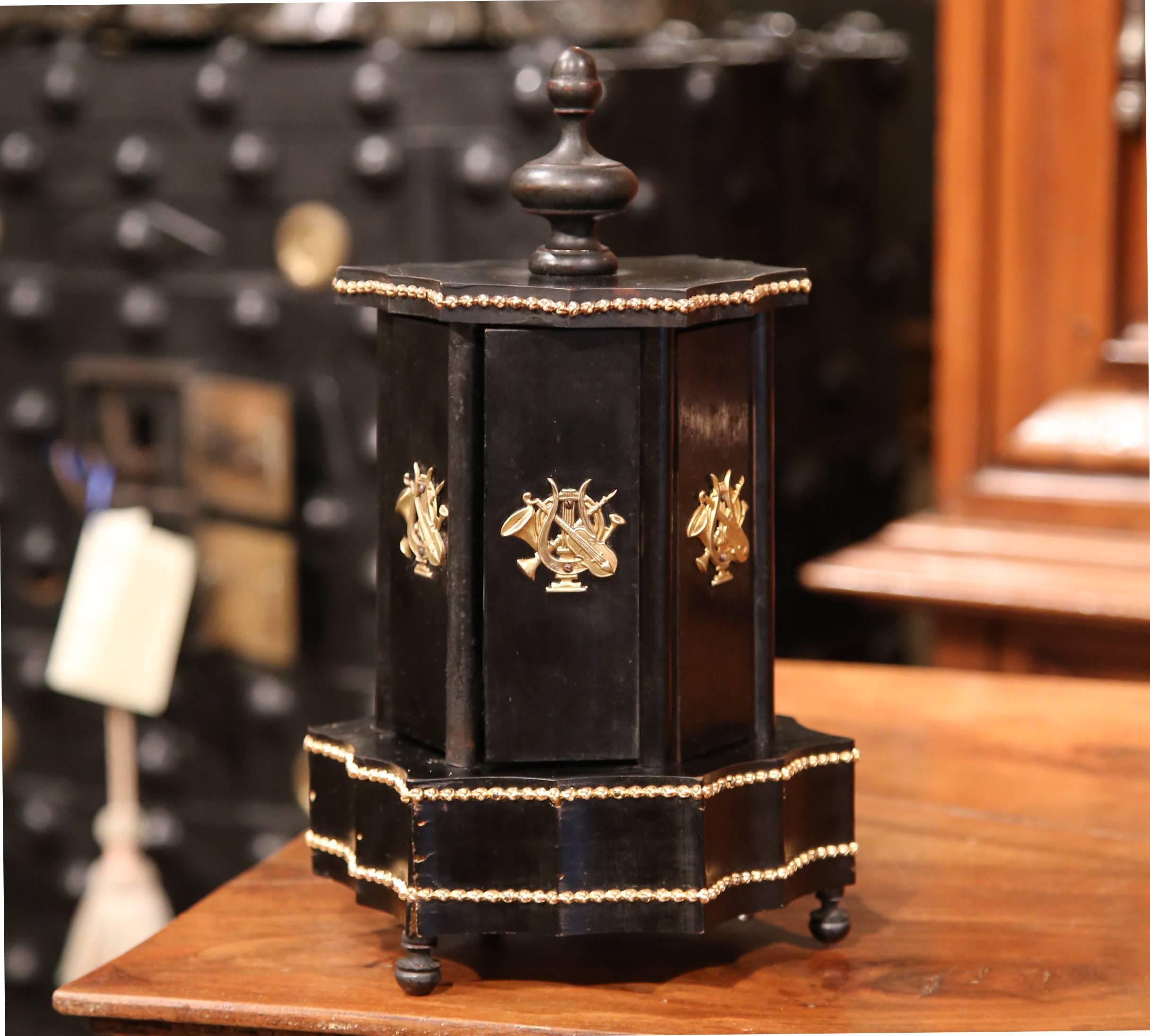 Elegant antique rosewood box from France, circa 1870; the twelve cigars holder features a rotating top finial with open and close mechanism where music can be heard. The outside of all six doors features brass mounts with music instruments including