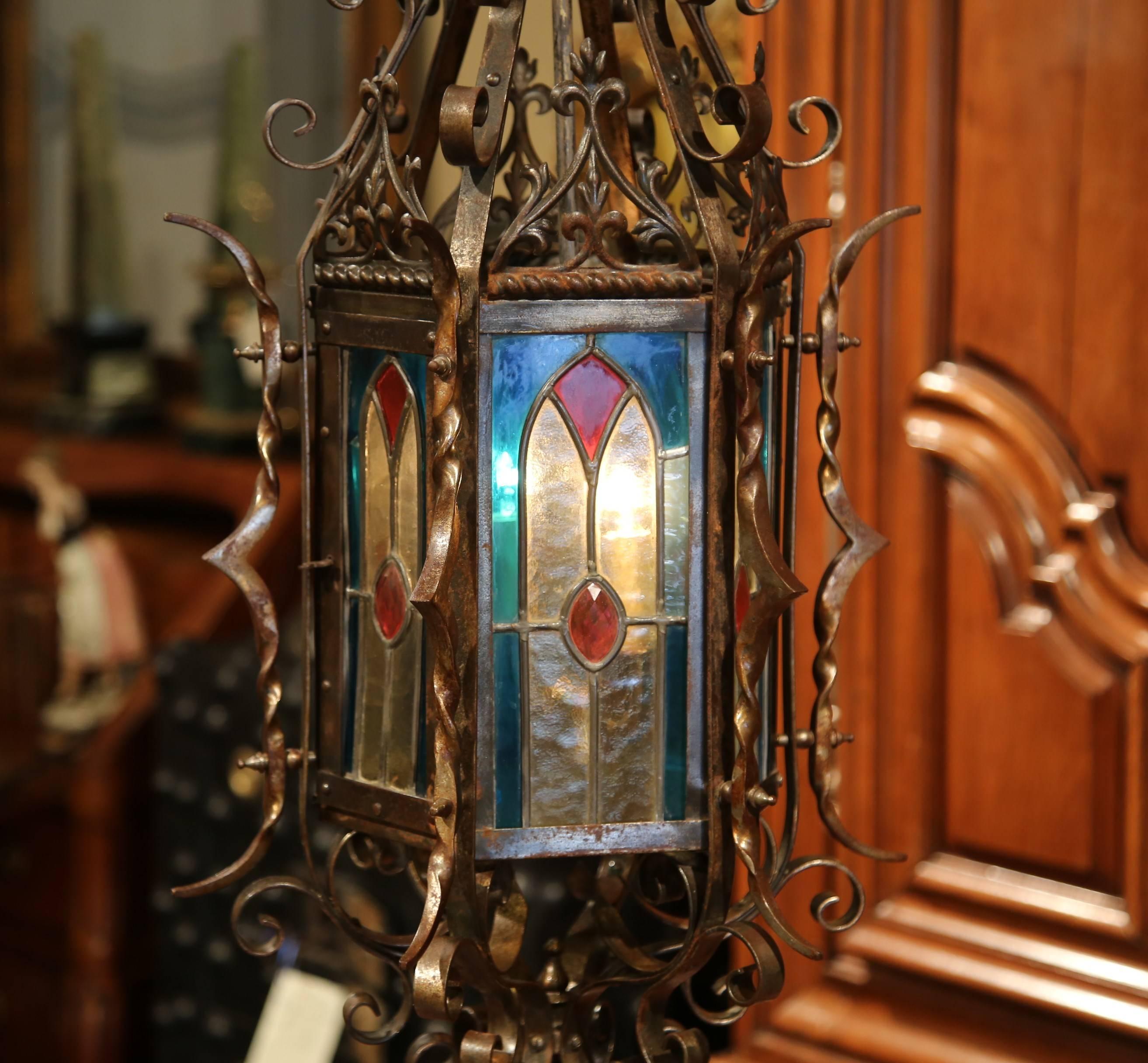 For a unique lighting feature, look no further than this beautiful, antique Gothic lantern from France, circa 1870. The French two-light hanging lantern features six painted, stained glass panels embellished with Fleur-de-Lys, and a small door to