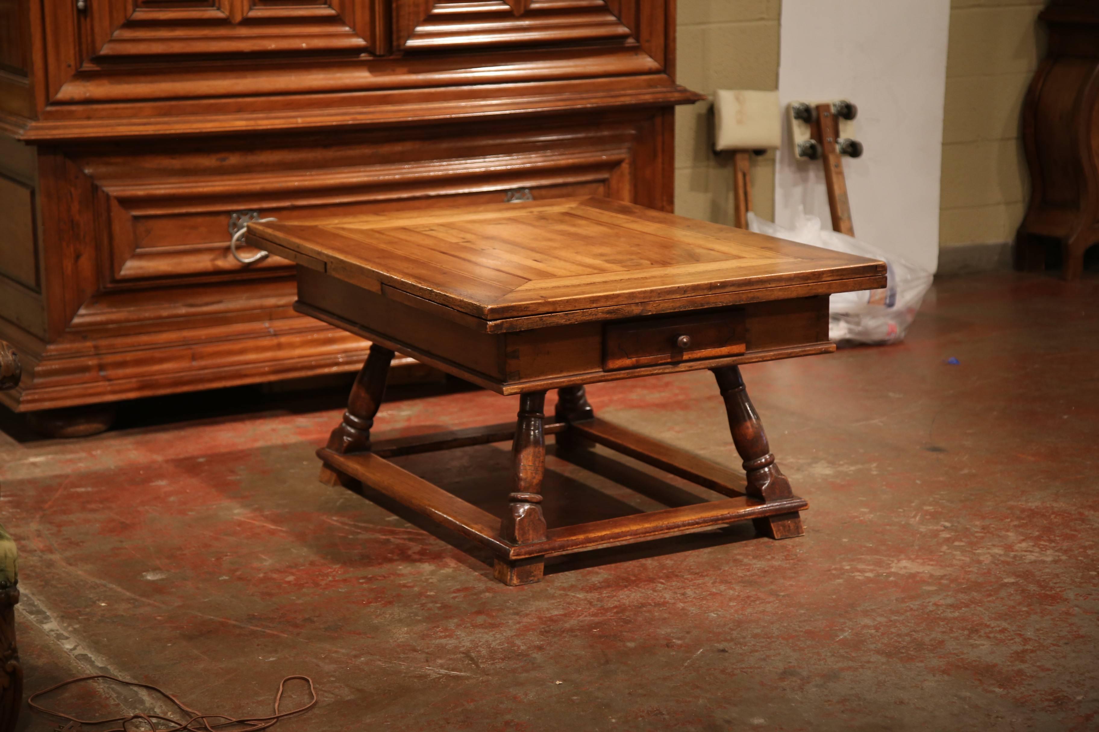 This rustic, antique fruit wood coffee table was crafted in Eastern France, circa 1780. The classic cocktail table features a parquetry top with two pull-out leaves under the surface and drawers at each end. The solid, square top has four turned