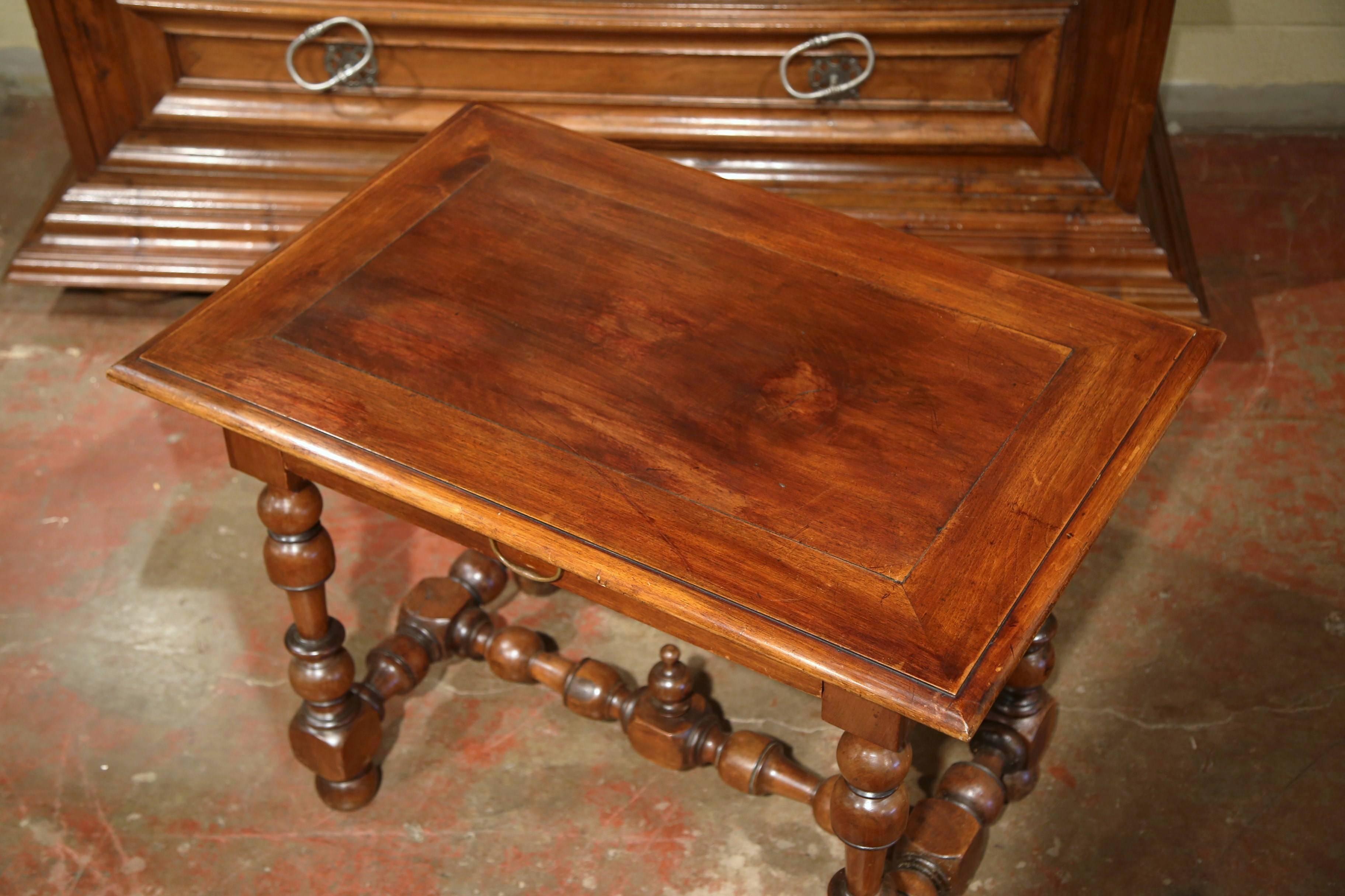 Incorporate extra, functional surface space into your living room with this elegant fruitwood end table. Crafted in the Perigord region of France, circa 1840, this table desk features a large single drawer across the front with brass handle. The
