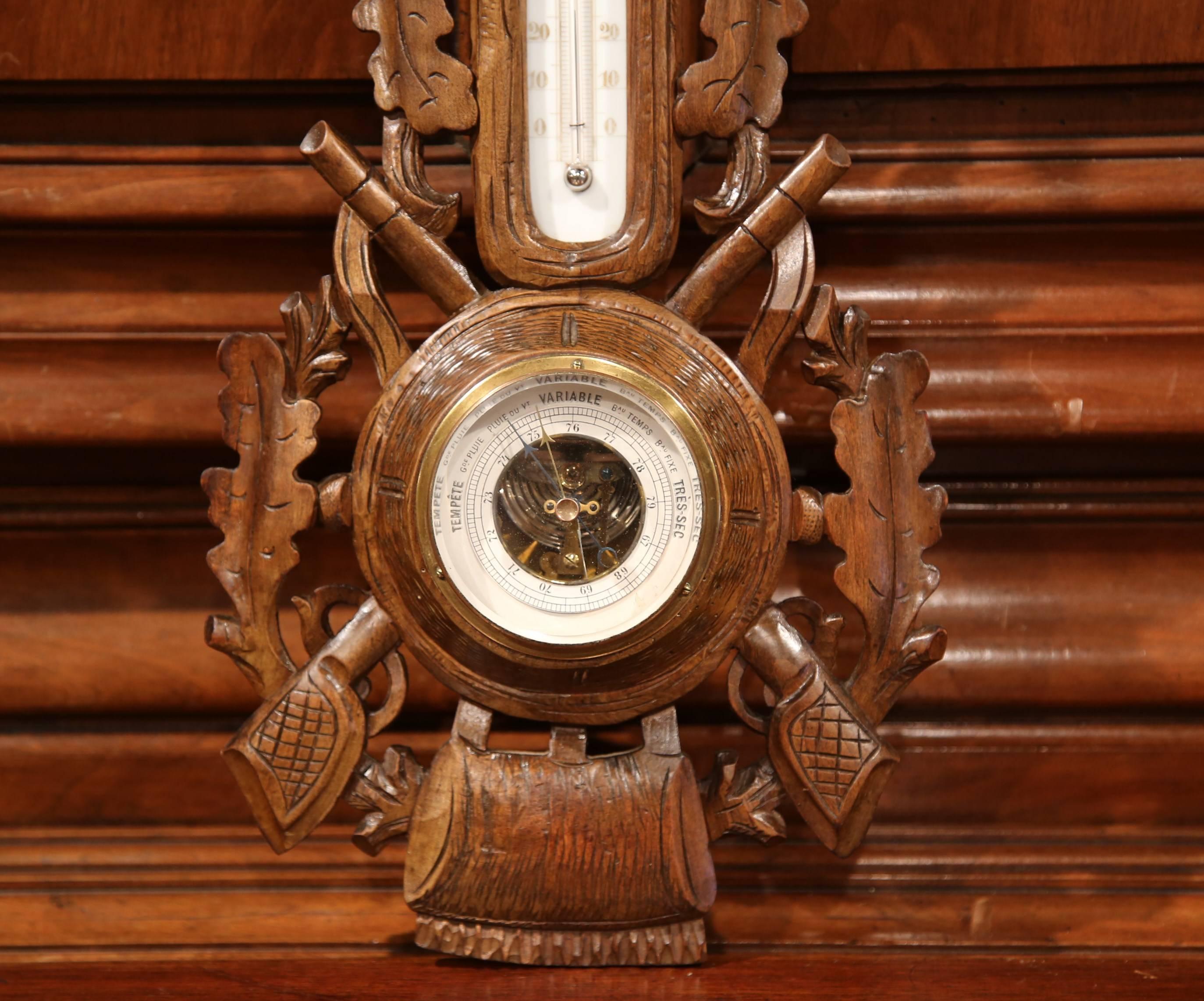 This elegant antique wall hanging barometer was crafted in France, circa 1880. The decorative weather and temperature reading device is embellished with a traditional hunting theme including a carved deer at the top, hunting guns, leaves on either