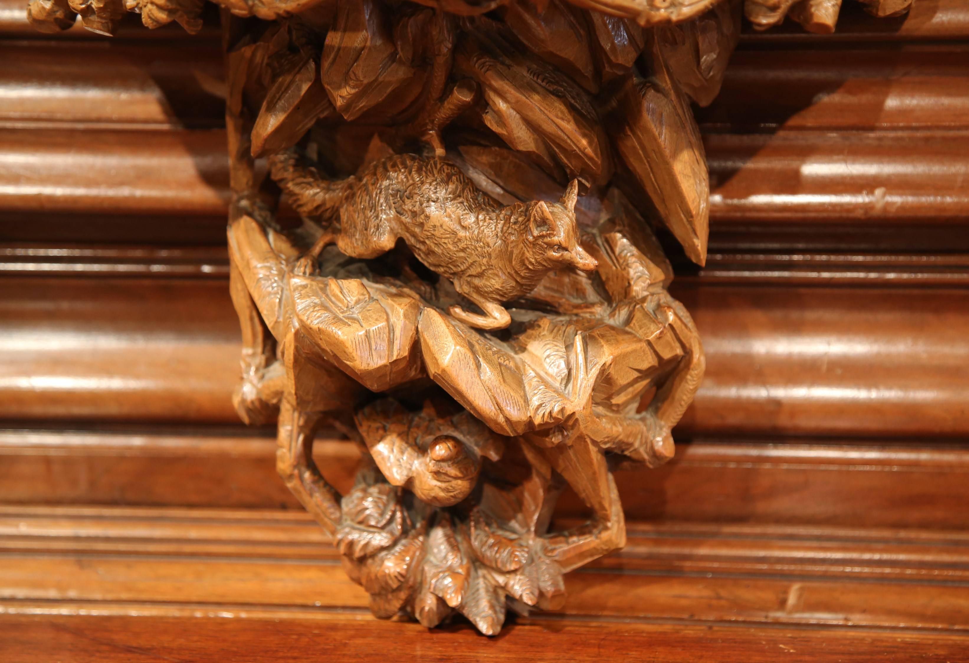 This beautifully antique wall bracket was carved in the Alps Mountains of France, circa 1880. Half circle in shape, the fruitwood shelf console features fine hand carved nature motifs including a fox, bird, foliage and branches. The piece is in