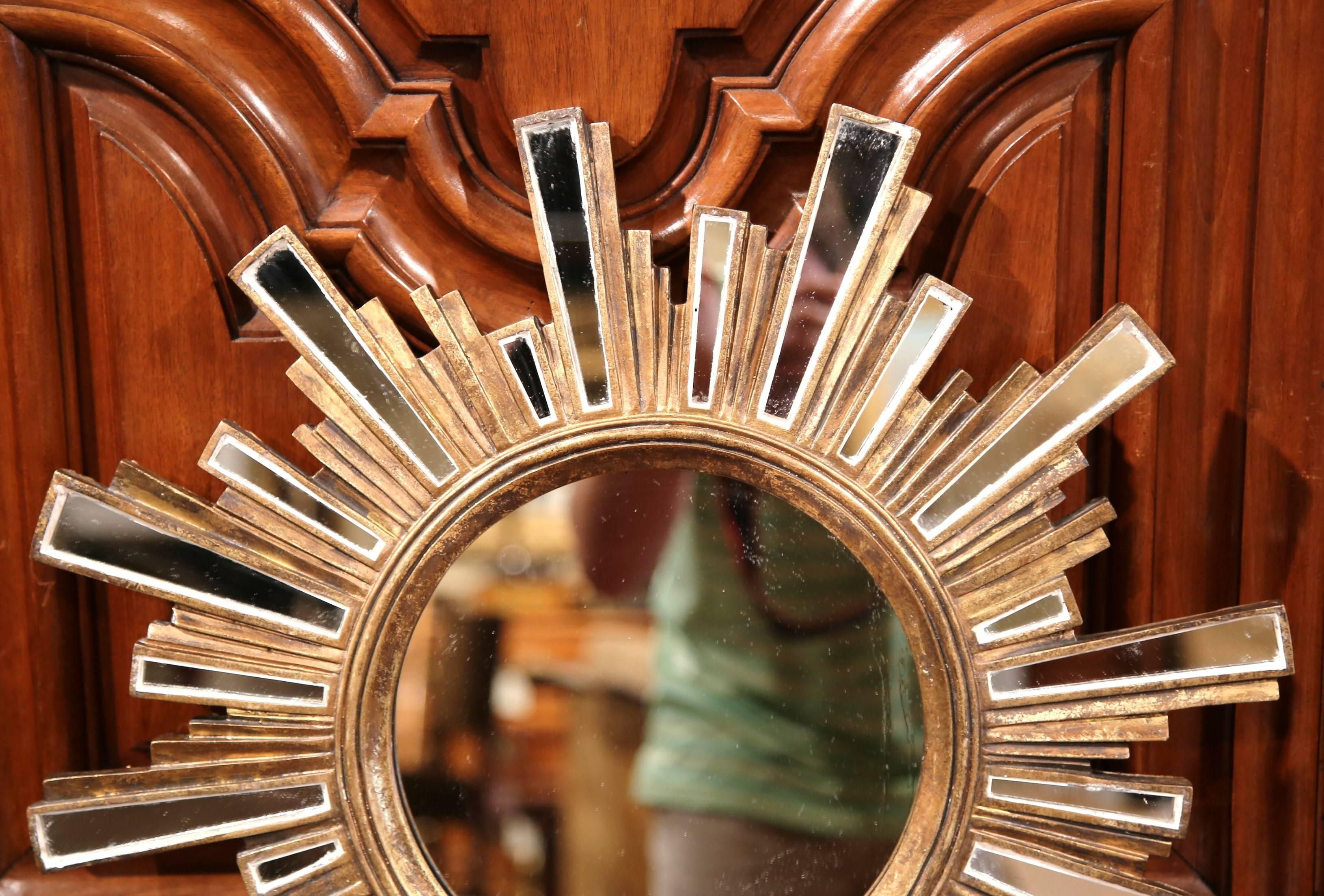 This beautiful vintage sun mirror was crafted in France, circa 1960. The small, elegant wall hanging mirror features a round centre glass with smaller, rectangular, mirrored beams exuding outwards. The statement making mirror is in excellent