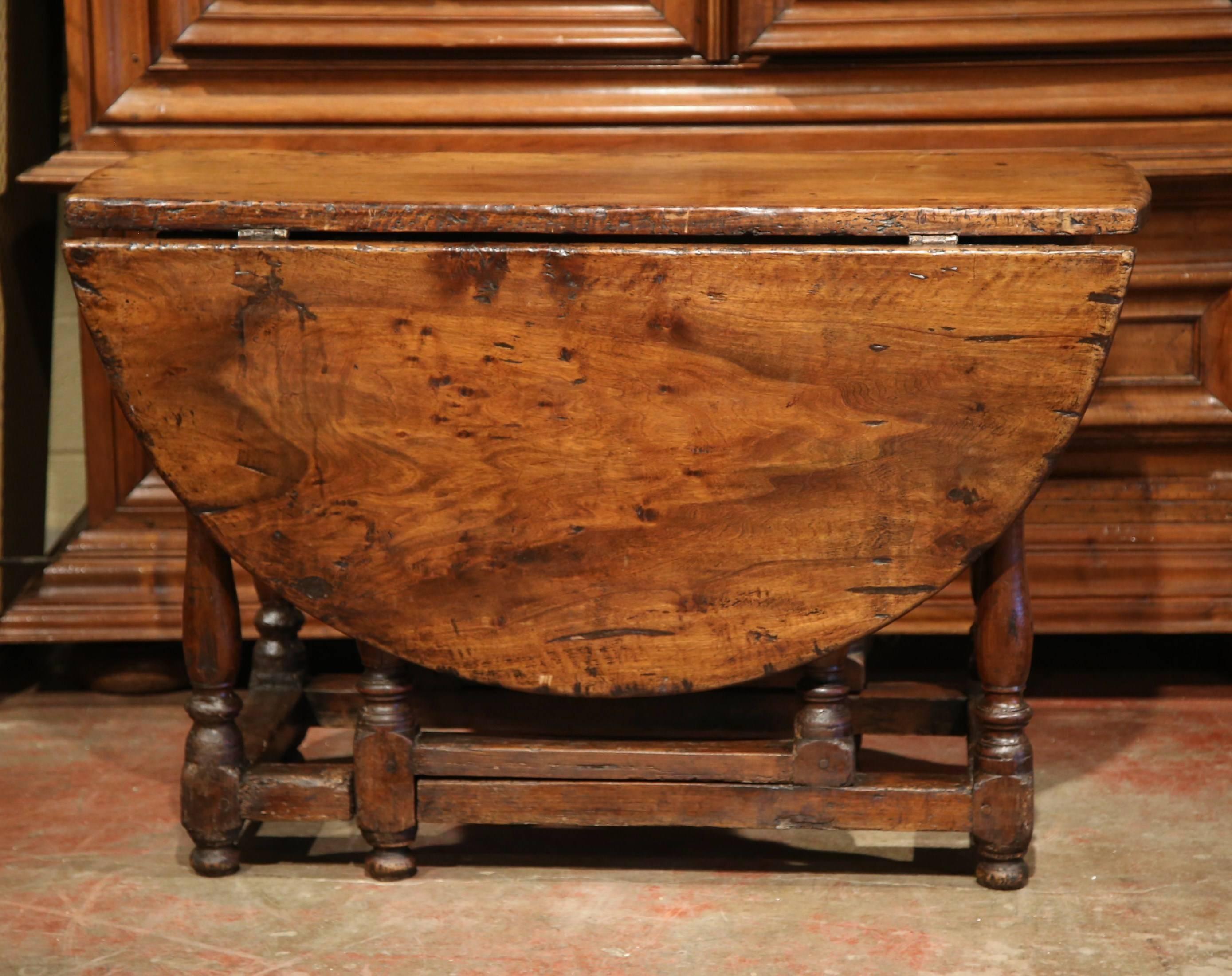 Make room to entertain many guests with this large, oval fruitwood drop-leaf breakfast room table from the Perigord. Crafted in Southern France, circa 1780, this Louis XIII table features 8 turned legs with stretcher in between and a large drawer