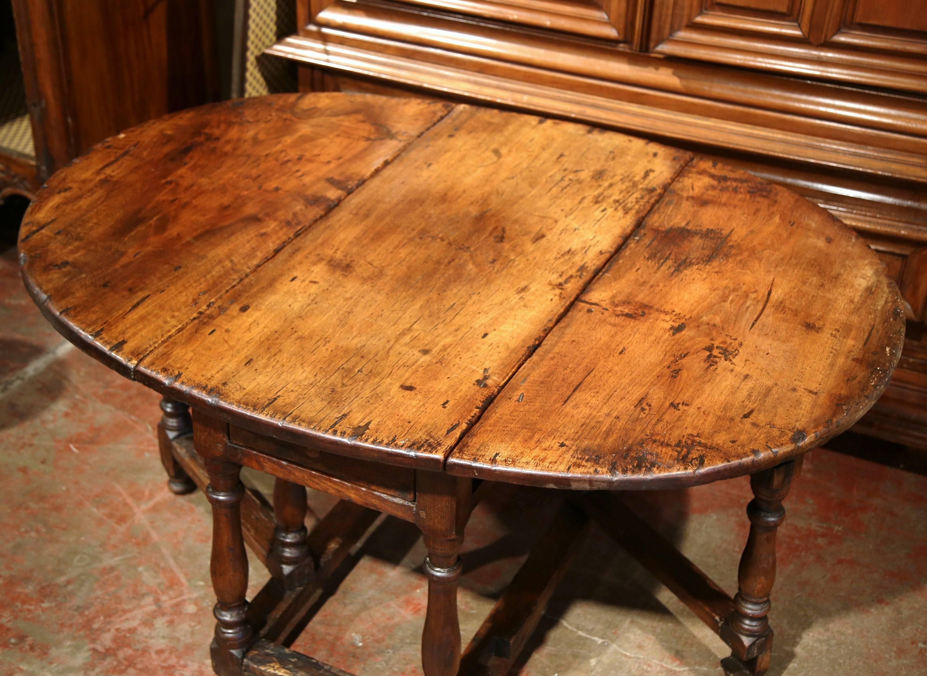 Patinated 18th Century French Carved Walnut Eight-Leg Oval Drop-Leaf Table with Drawer