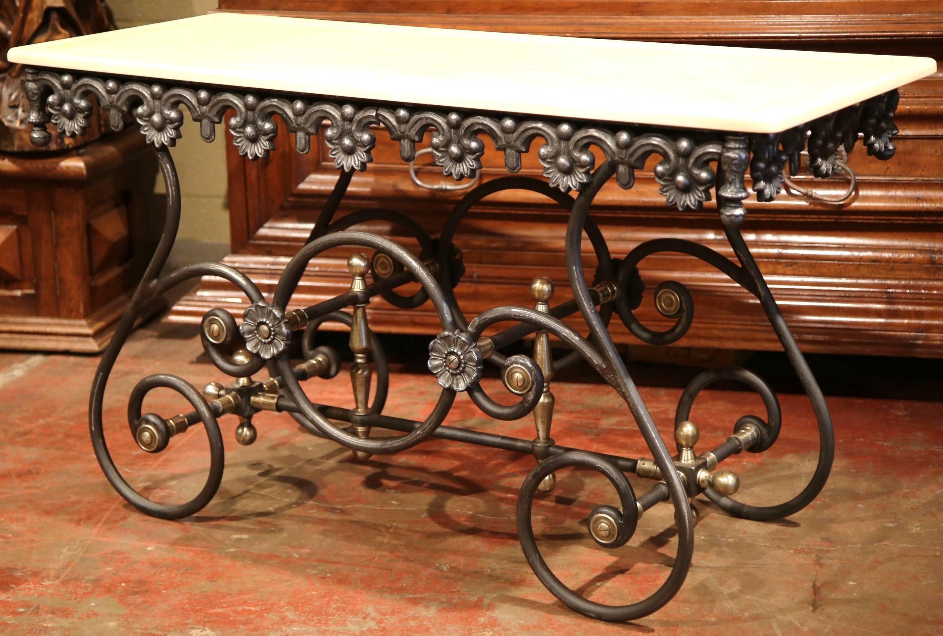 This long, narrow French butcher table (or pastry table) would add the ideal amount of surface space to any kitchen. This table has a polished iron finish and features a scalloped apron with intricate metal work and beautiful scrolled legs with