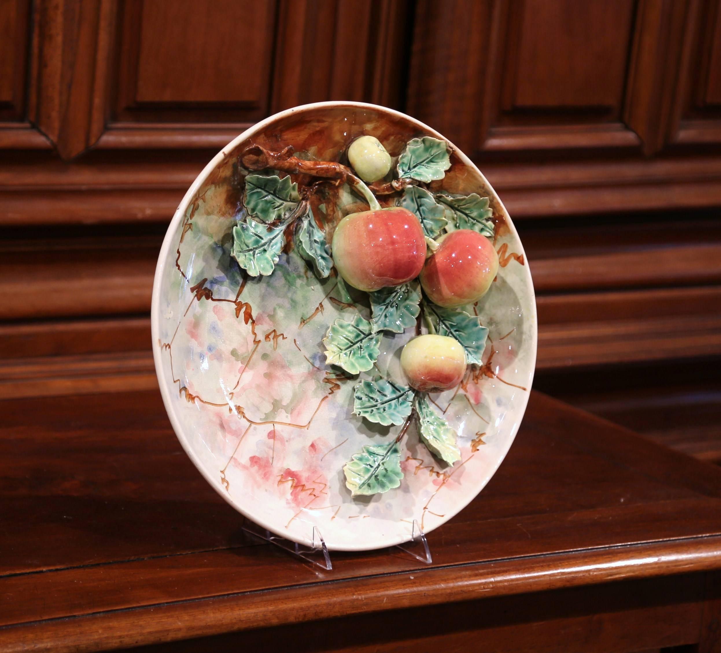 Hang this pair of large, colorful Majolica plates on your kitchen wall or display them on a shelf. Sculpted in France in the manner of Longchamp, circa 1870, one porcelain plate has four red and yellow apples hanging from a tree branch covered with