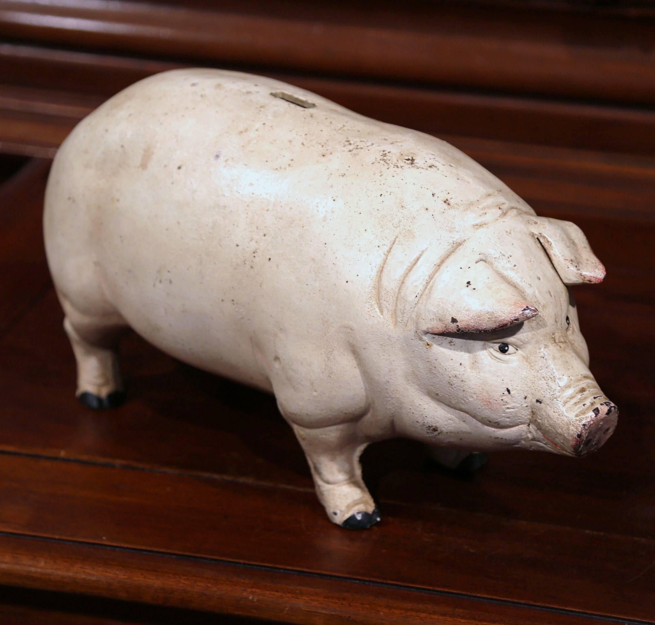 Crafted in France, circa 1880, the large hand painted iron pig sculpture has a beautiful beige patinated painted finish, and a very realistic shape and details. The bank is equipped with a slot for coins and a key open it and retreive the savings.
