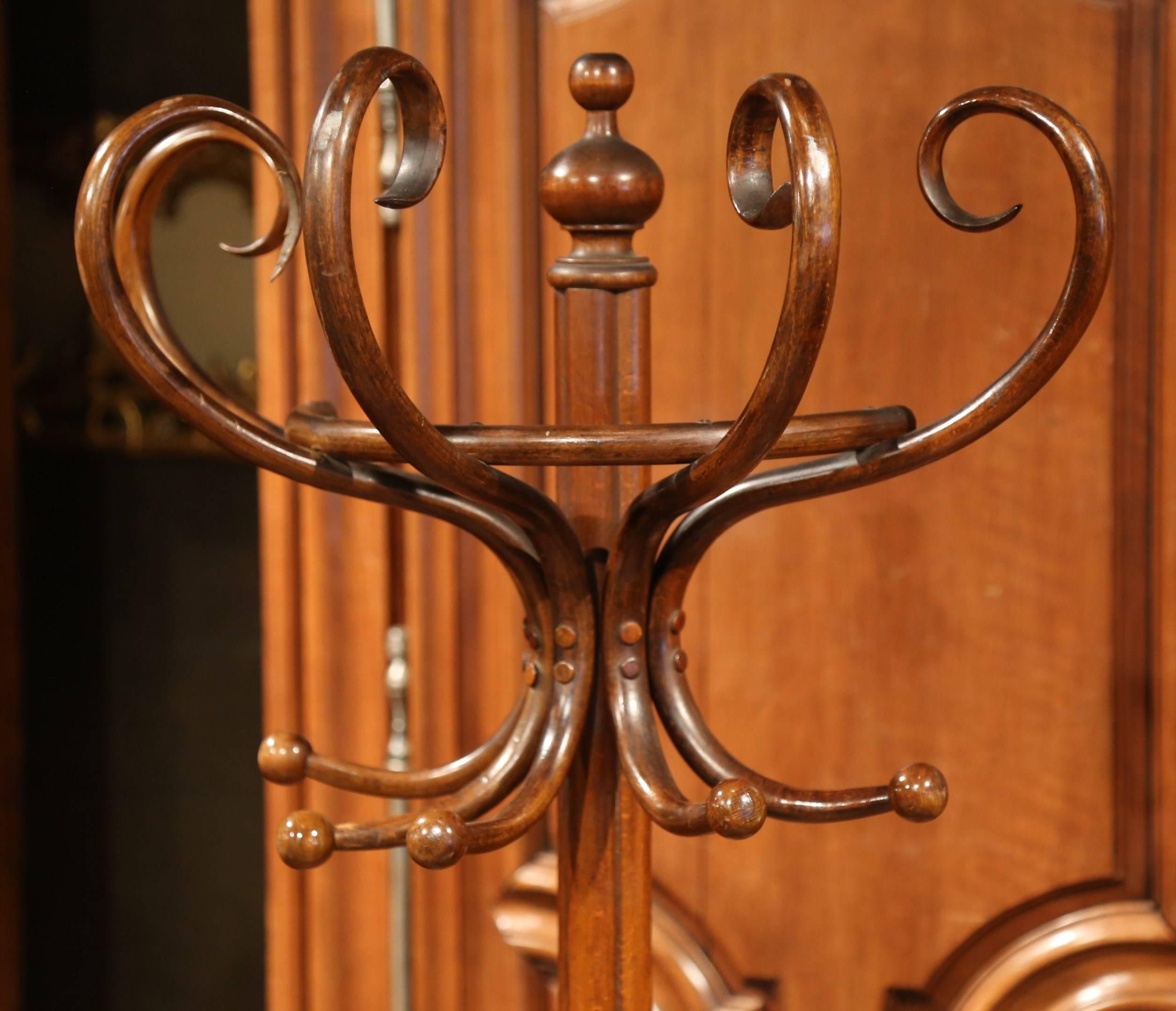 Bring a retro, yet practical touch to any entry or dressing area with this elegant, carved coat and hat stand. The wooden stand was crafted in Paris, France, circa 1920, after the German-Austrian cabinet maker, Michael Thonet (1796-1871). The