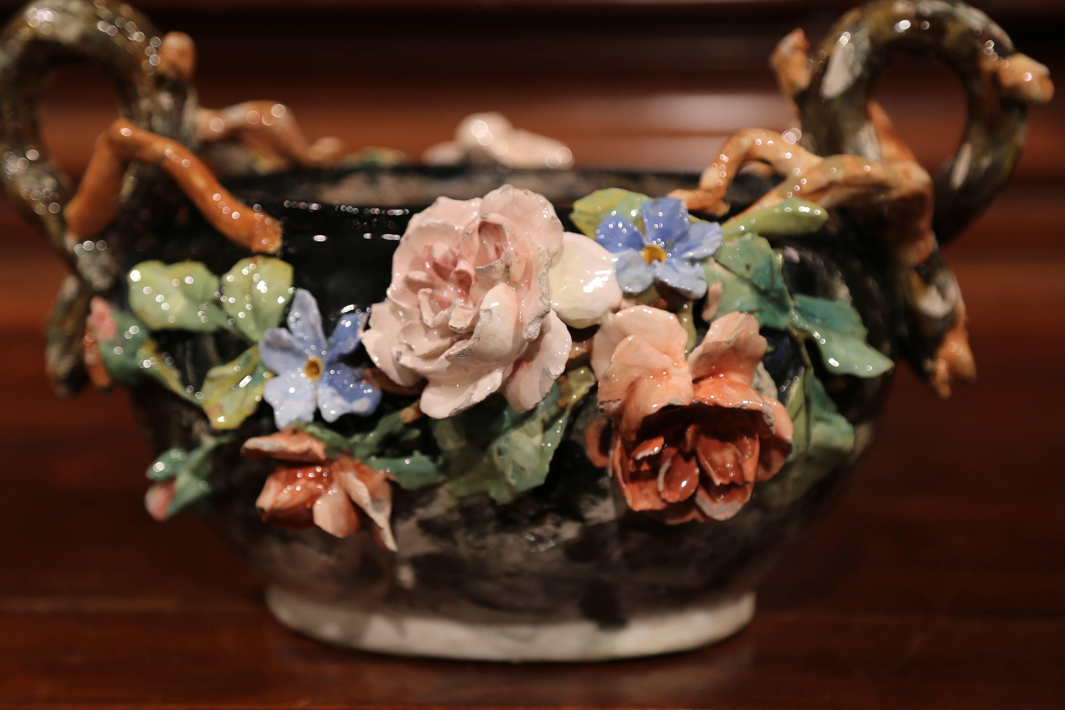 Dieses elegante, farbenfrohe, handbemalte Pflanzgefäß aus Majolika wurde um 1860 in Montigny sur Loing, Frankreich, hergestellt. Die Jardiniere aus Keramik mit wurzelförmigen Griffen zeigt hochreliefierte zartrosa, blaue und beige Rosenblüten mit
