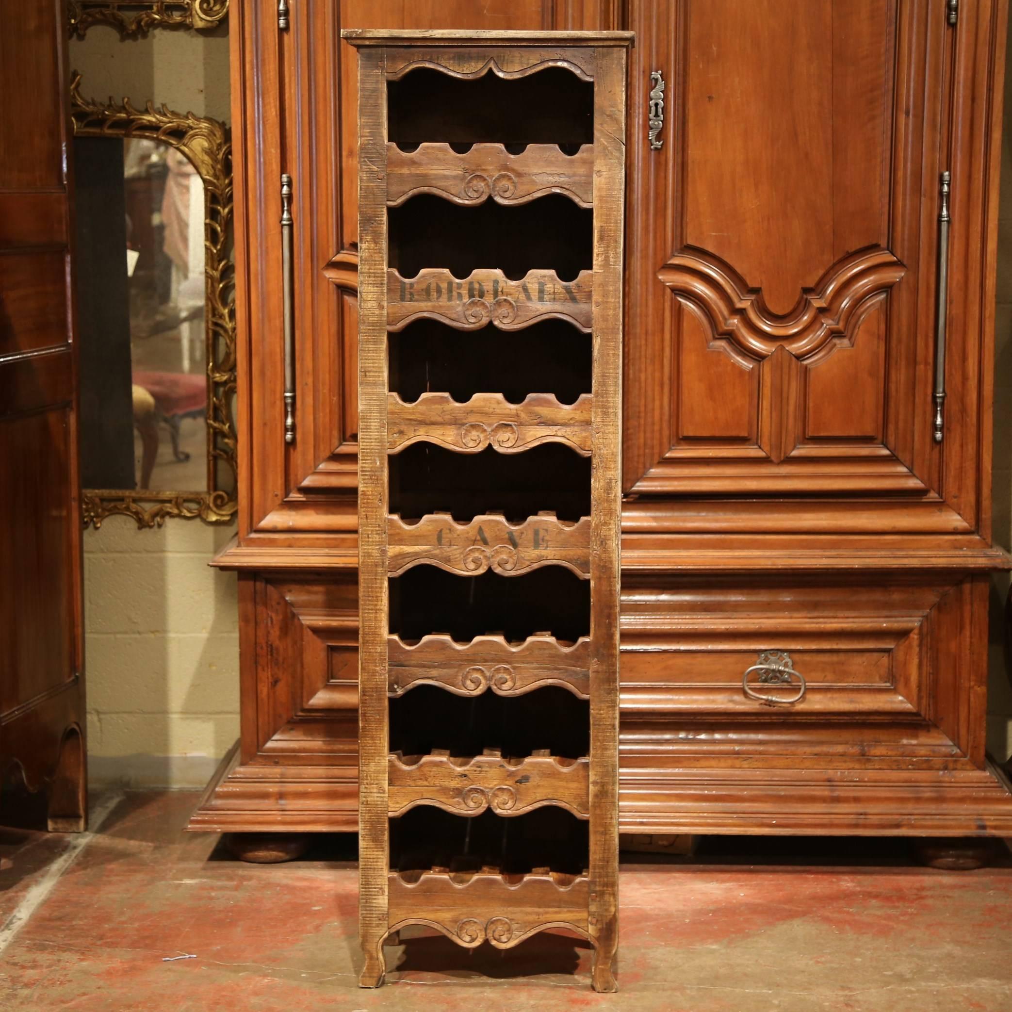 This elegant, antique wine storage cabinet was crafted in France using old timber. The tall and thin wine rack has four small curved feet and apron, and seven shelves. Each row will hold up to four bottles, so 28 bottles total. The cabinet has the