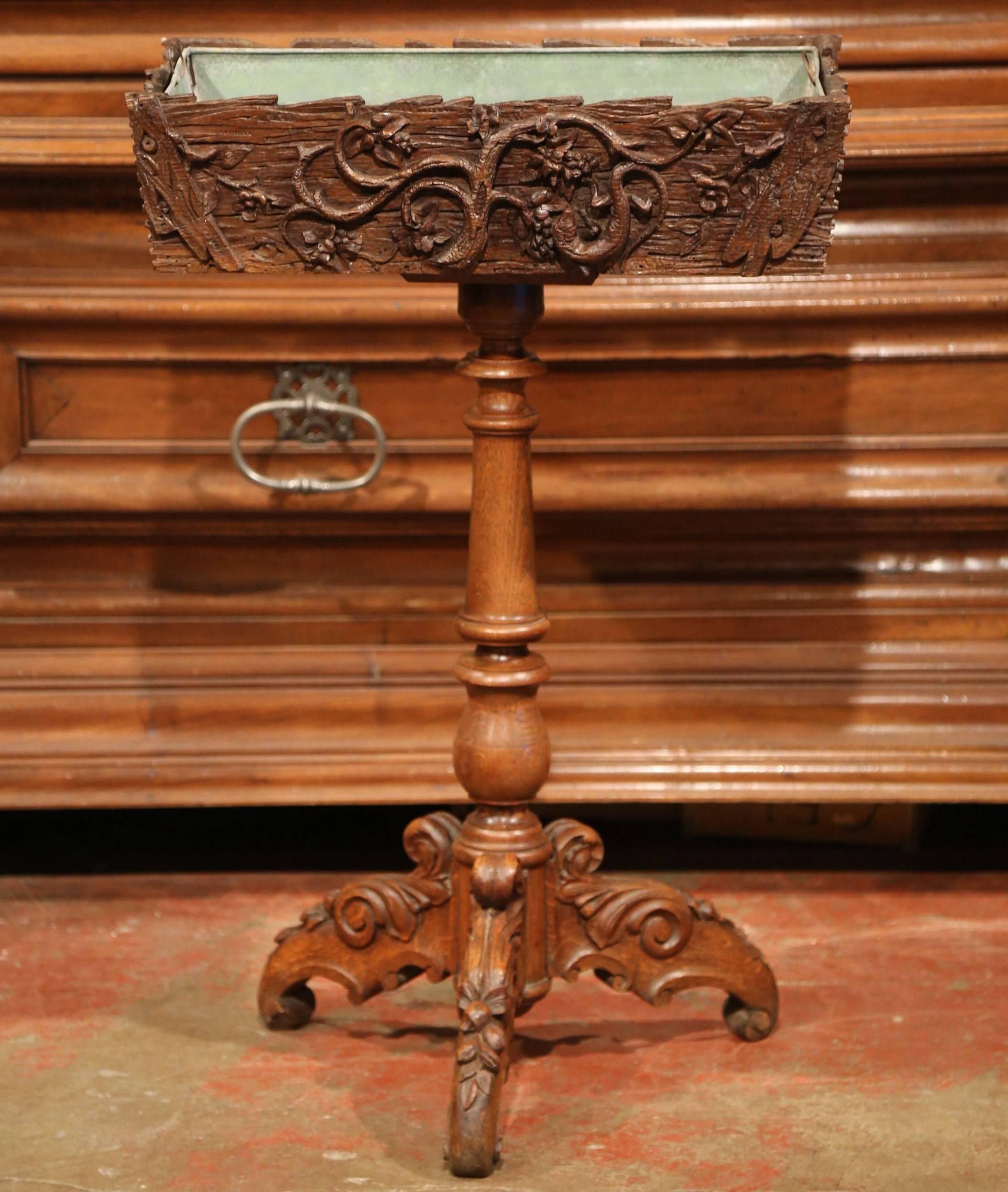 This beautiful, walnut antique Black Forest jardinière was carved in France, circa 1870. The elevated fruitwood planter features hand-carved flowers, tree branches with leaves, and a hand-carved lizard. It has the original removable inside zinc