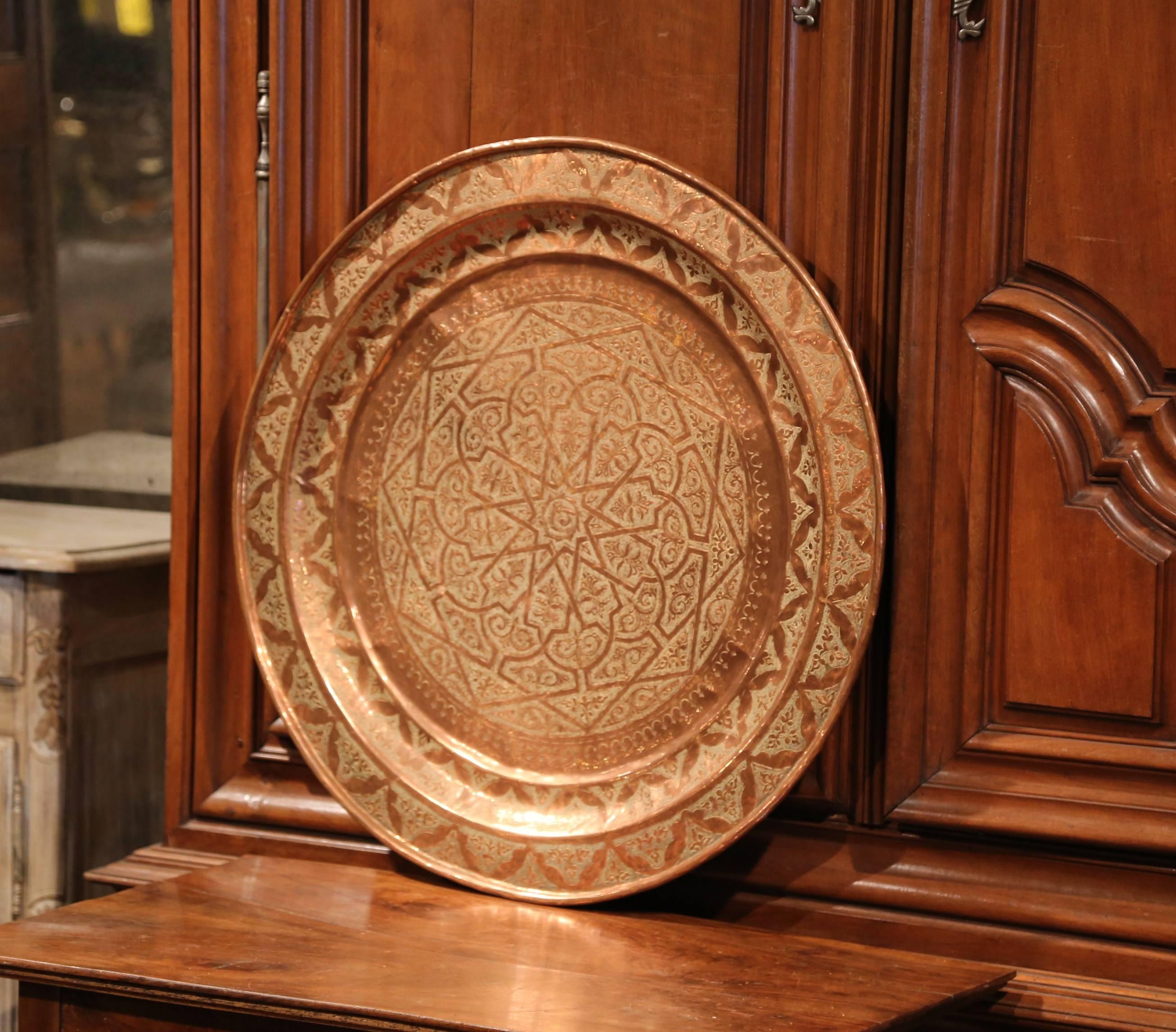 This large, turn of the century tray was crafted in France, circa 1920. The round tray has engraved, geometric motifs with a star in the centre. The tray is surrounded by a raised edge with a looped treatment and has a back hook for easy hanging.