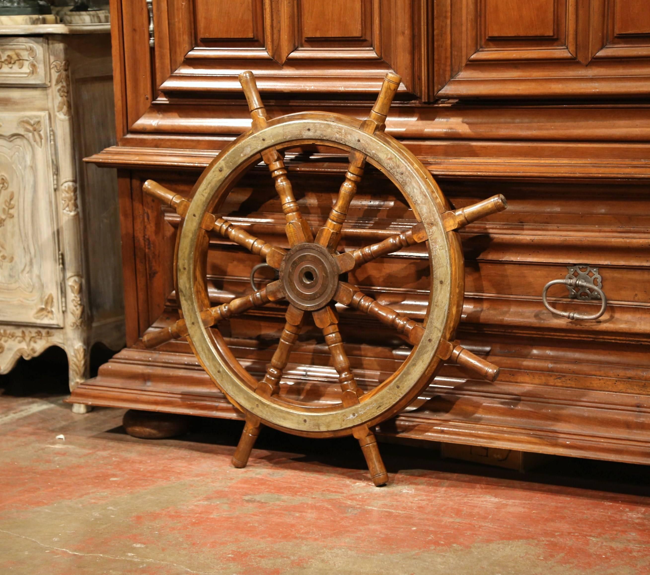 This antique wooden ship wheel was carved in France, circa 1880. The traditional, fruit wood nautical object has its original metal brace, eight turned handles and is in excellent condition with original walnut patina. This classic wheel would make