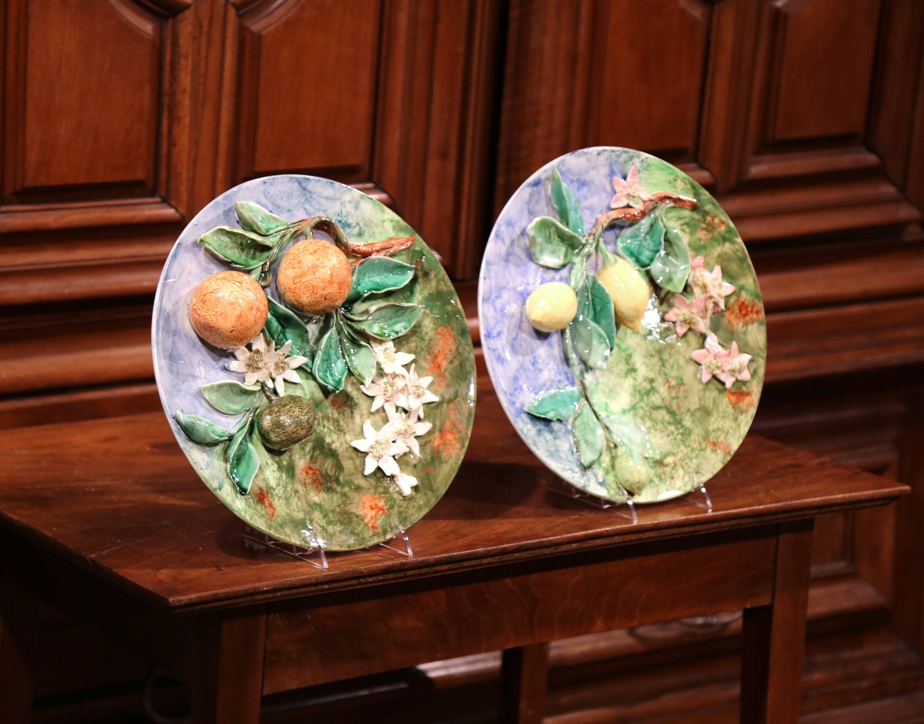 Add some color to your kitchen or dining room with this beautiful pair of antique Majolica plates from France, circa 1880. Embellished with a high-relief, sculptural fruit motif that includes oranges and lemons hanging from tree branches covered