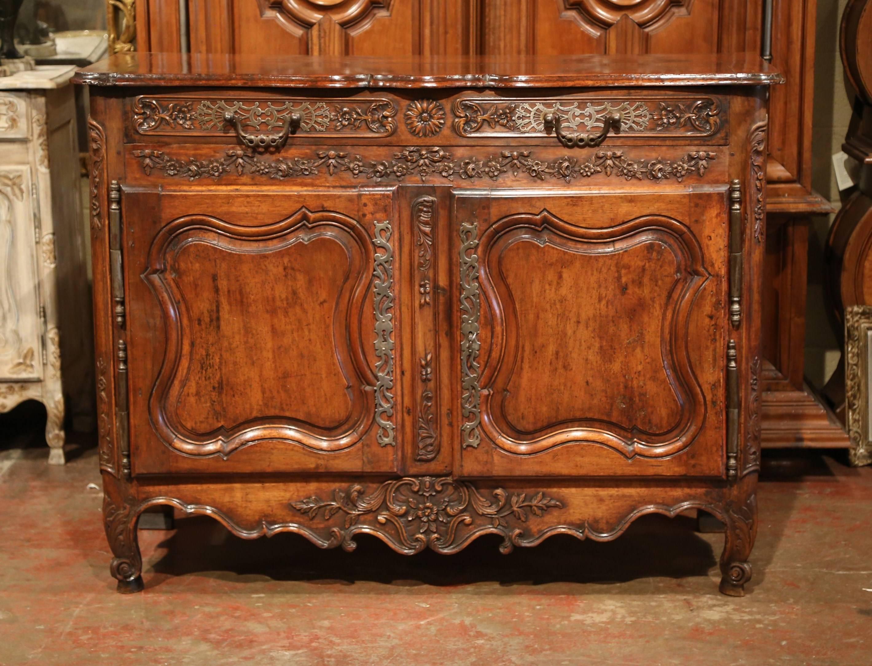 This elegant, antique fruitwood buffet was carved in Southern France, circa 1760. The Classic cabinet exemplifies the Louis XV style with a heavy presence, beautiful lines and intricate carvings. The cabinet has a long hand carved drawer across the