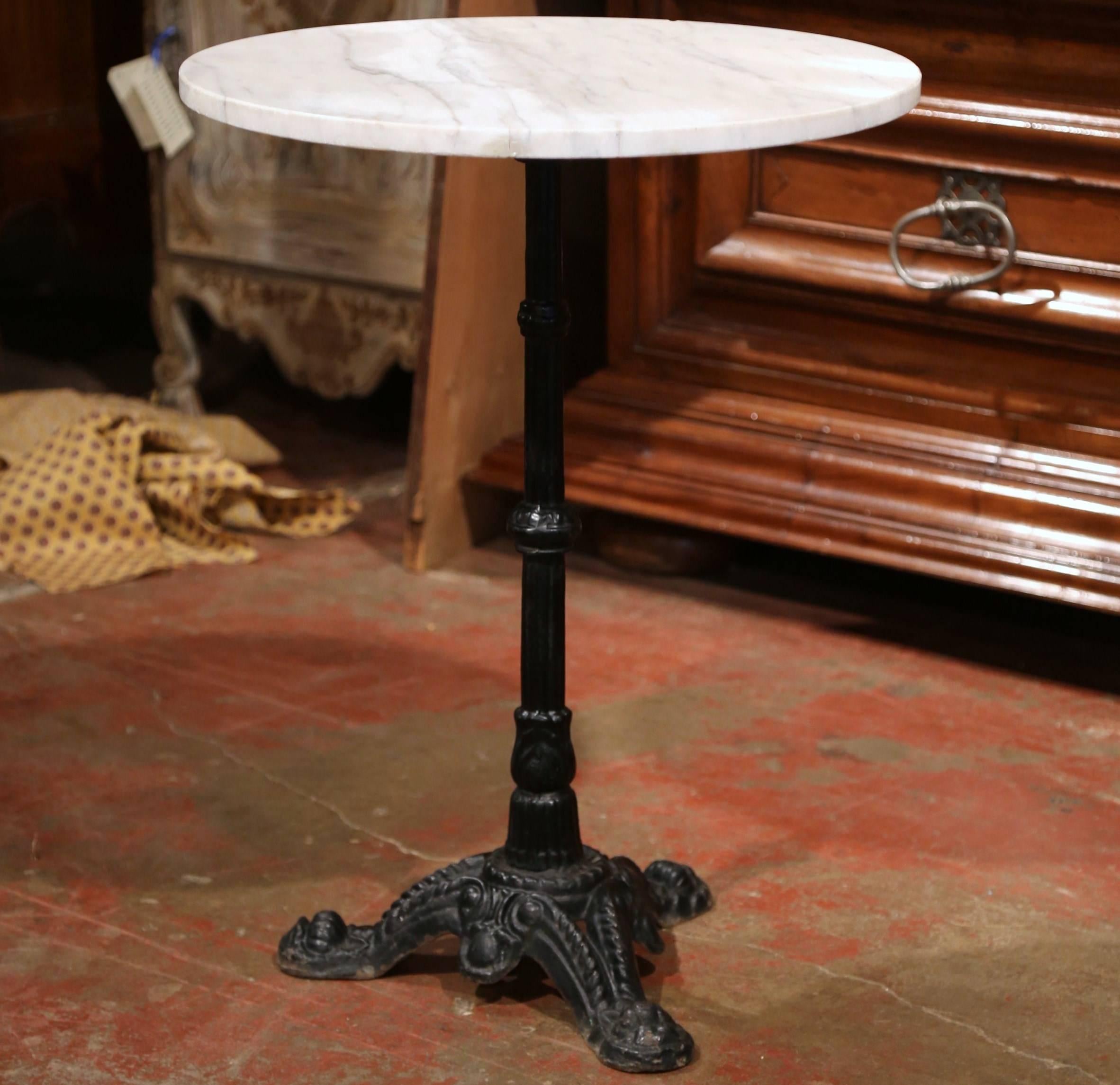This exquisite, antique Napoleon III gueridon was crafted in Paris, France, circa 1870. The classic bistrot table features a round white marble top with grey veins and a long, thin iron base with three paw feet. The French pedestal base is in
