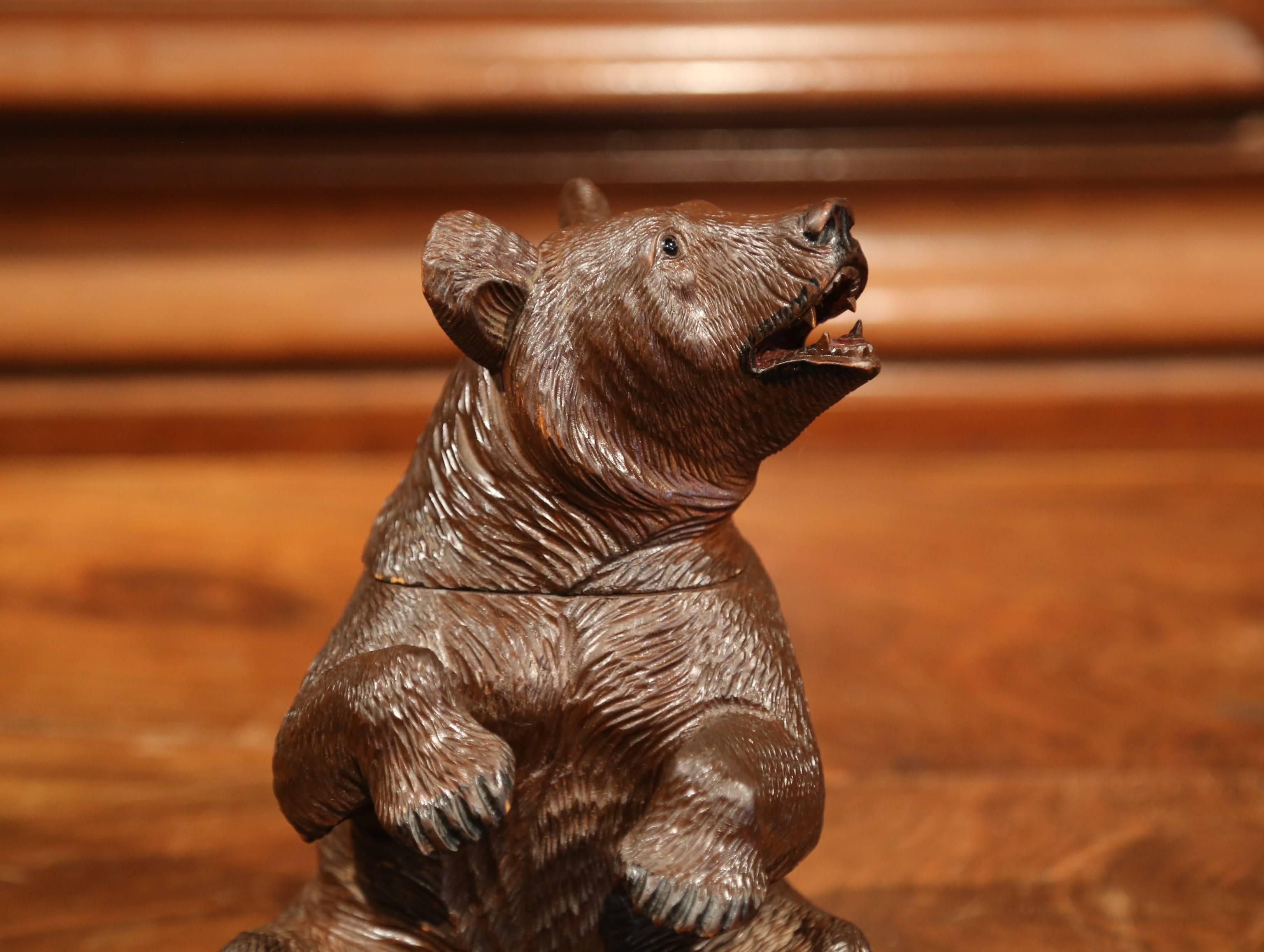 This beautifully executed, antique bear sculpture was crafted in Switzerland, circa 1870. The seated bear features exquisite hand carved details and is embellished glass eyes. The mammal with heavy skin has a sweet facial expression, and his head