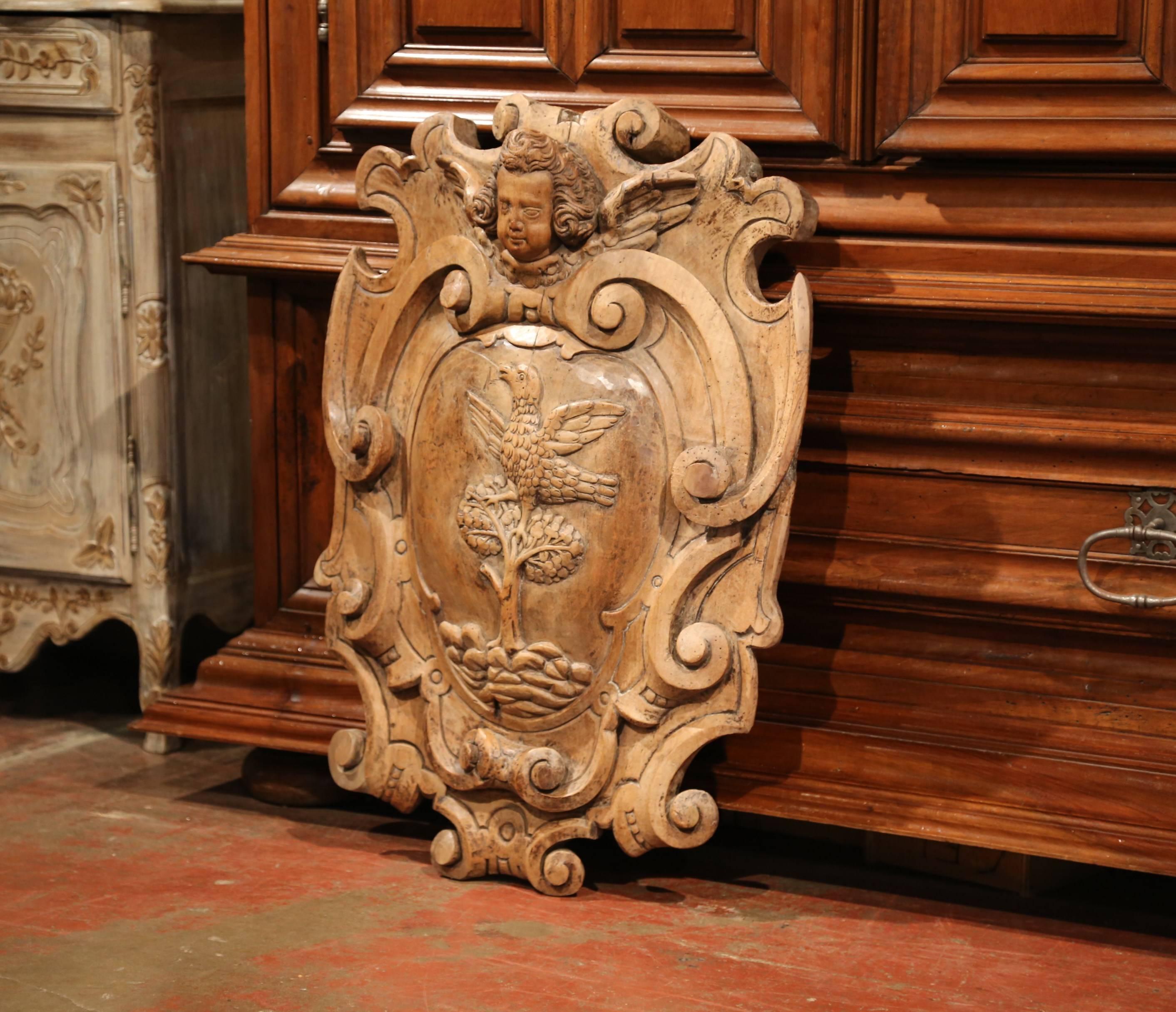 Beautiful fruit wood carving from southern France; crafted circa 1780, the large wall hanging piece features a thick bow front with hand carved elements including a dove perched on top of a tree and a cherub face at the pediment. Excellent condition