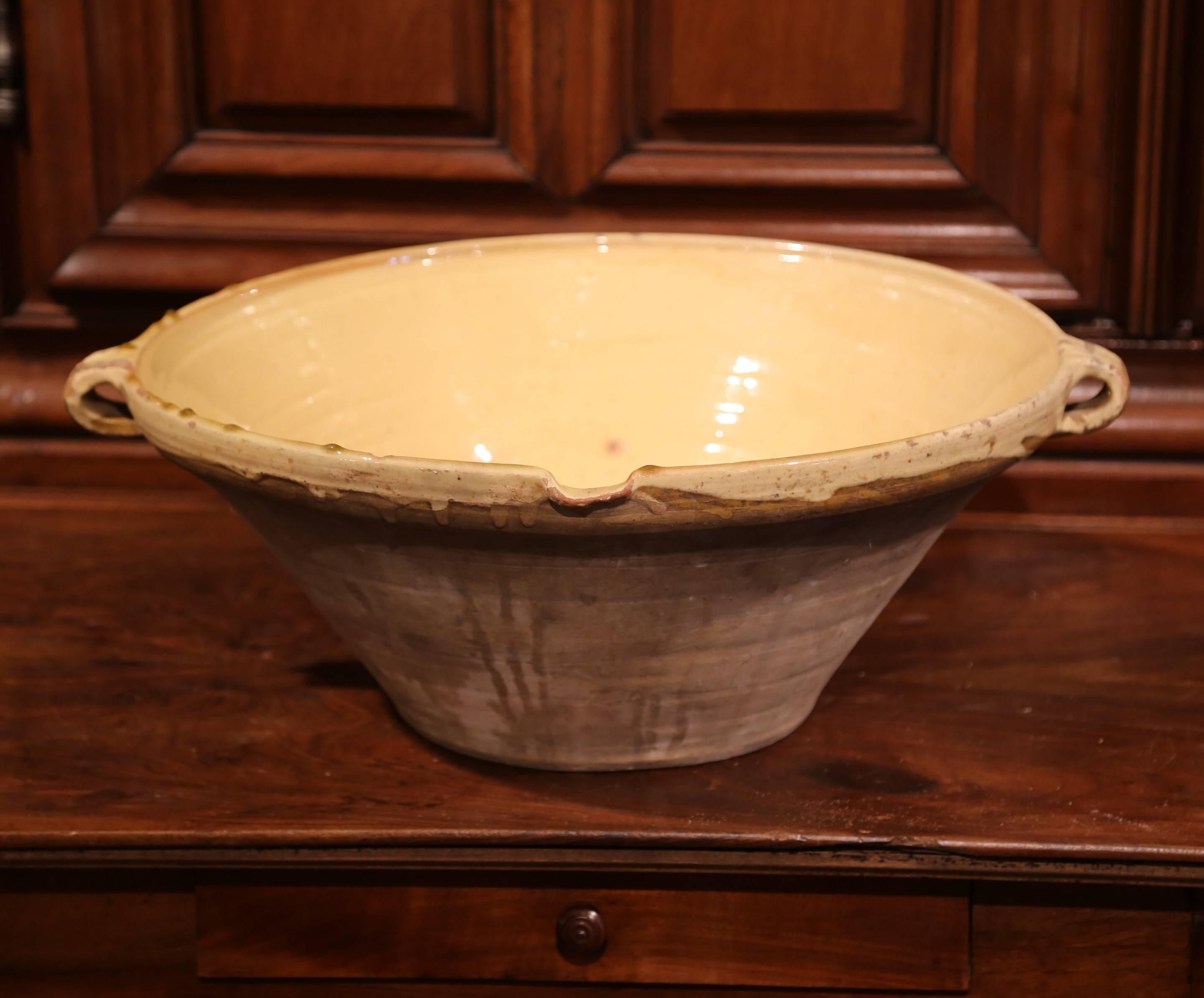 Beautiful antique Tian (Provencal term for bowl) from southern France; crafted in Provence, circa 1870, this round handmade terracotta bowl features two small handles, a server beak, and has a subtle yellow glaze on the inside with natural