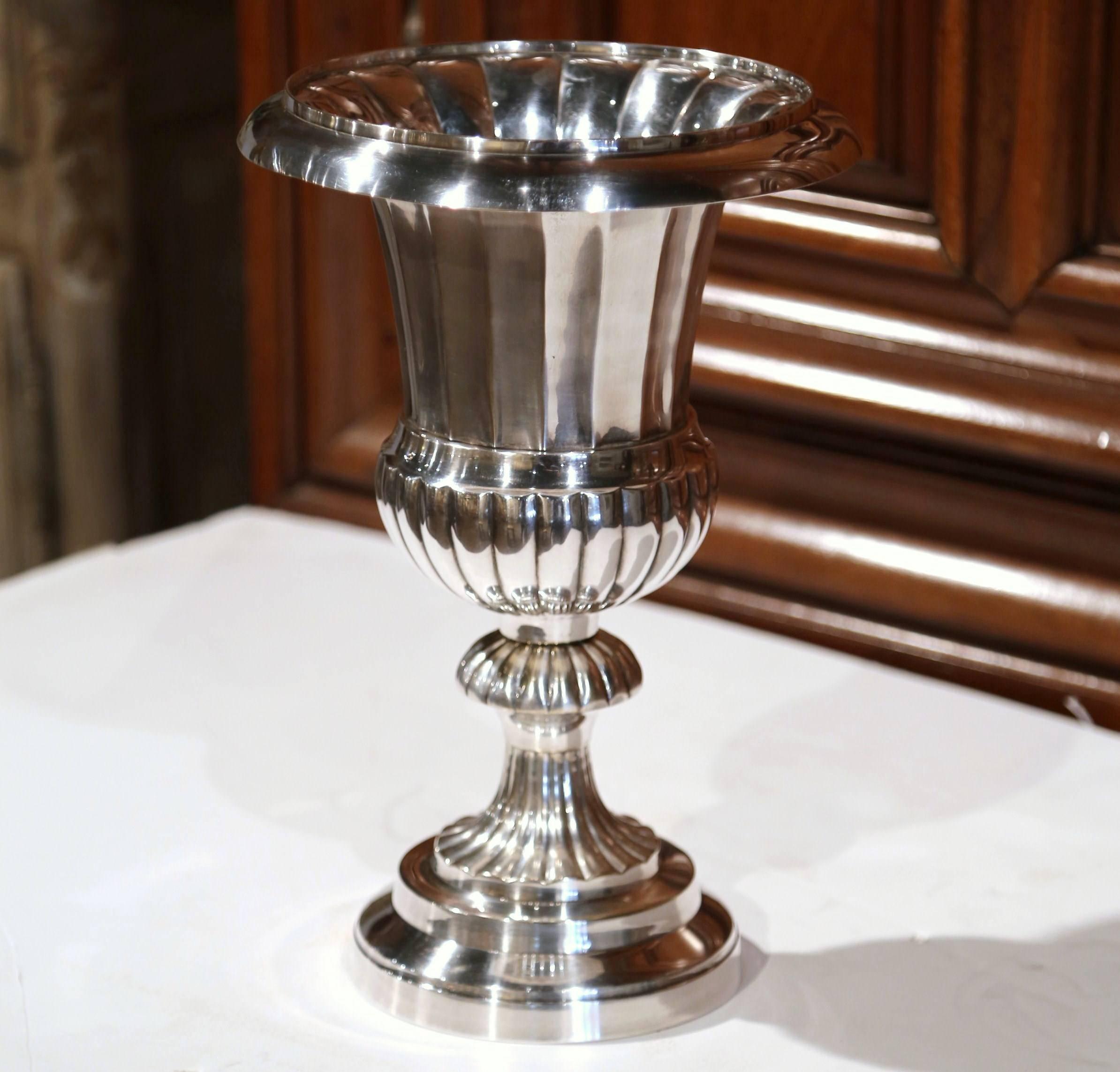 This tall and heavy antique wine cooler was crafted in England, circa 1920. The elegant champagne bucket is shaped like a classical vase, and features a beautiful silver plated finish throughout. On the base of the bucket, the markings read ESMC 22