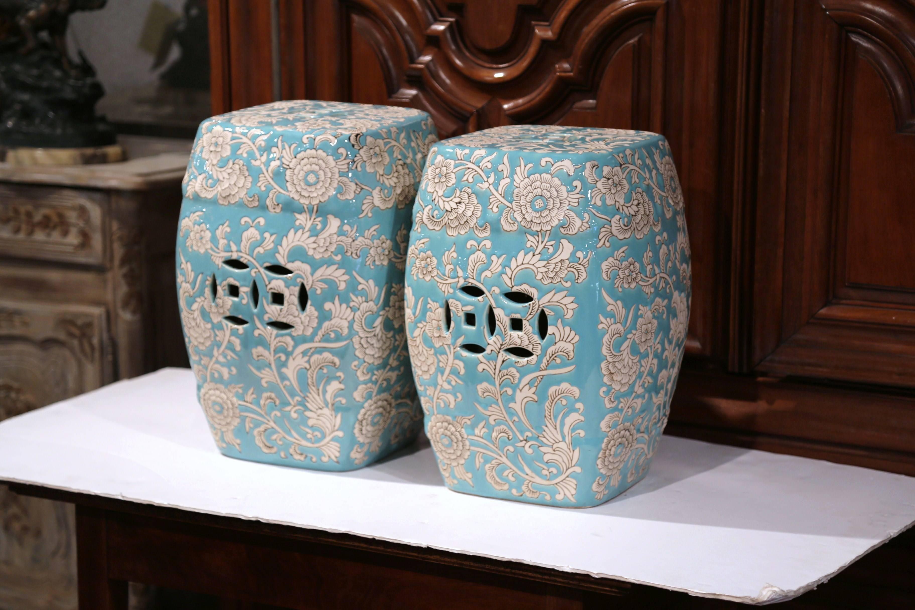 This interesting pair of colorful vintage garden stools were sculpted in China, circa 1970. The square porcelain stools have cut-out designs on all four sides and feature hand-painted flowers. The traditional, oriental ceramic stools are in great