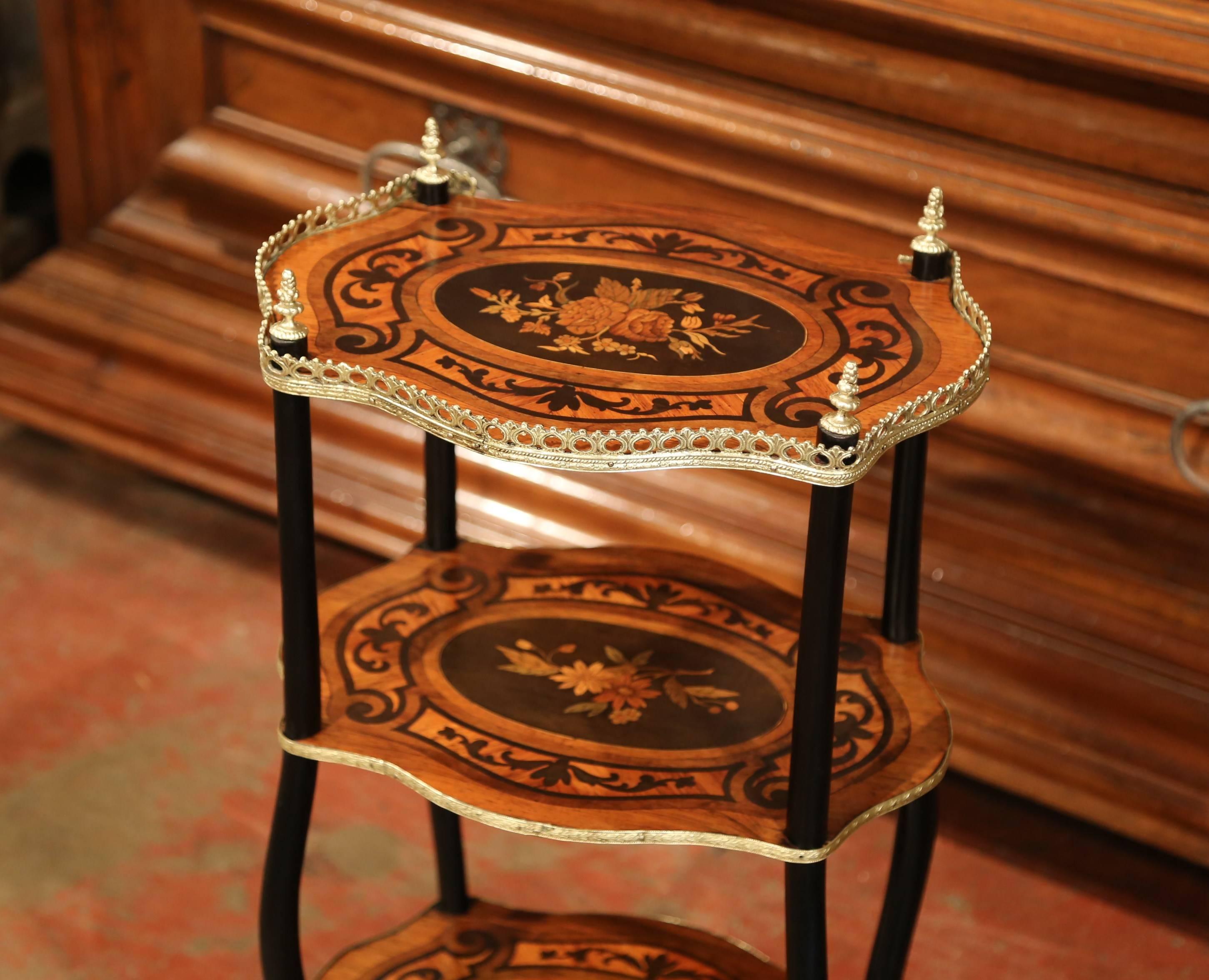 This elegant, antique small table was created in France, circa 1870. Oval in shape, this side table features a marquetry top with bouquet of flowers encircled by a bronze gallery and four finials. Underneath, the table has two additional shelves
