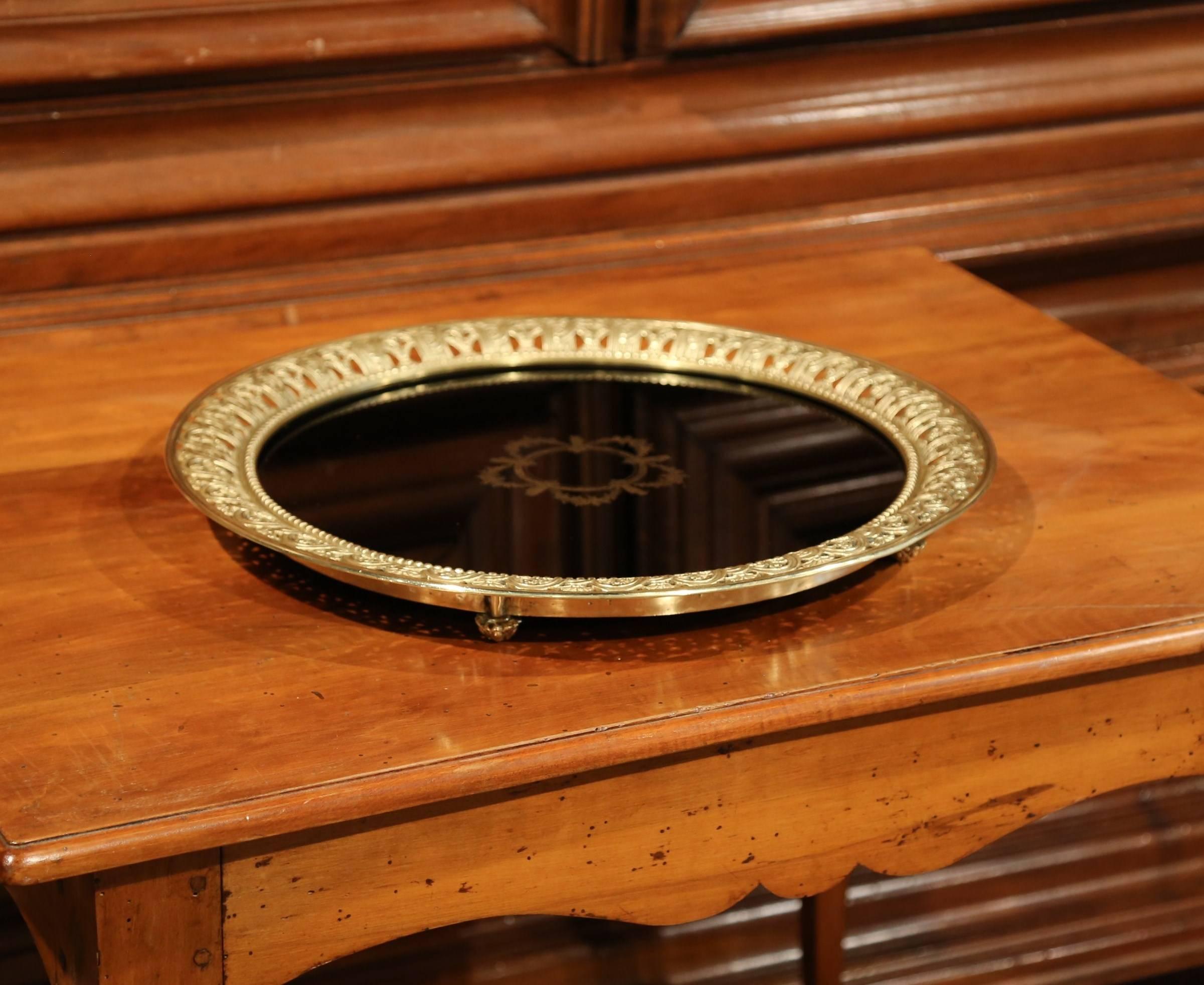 This elegant, antique tray was crafted in France, circa 1890. The Louis XVI plateau features an eye-catching black glass surface, decorated with gilt garlands and flowers in the centre. The round tray has an intricate bronze rim and four small feet.