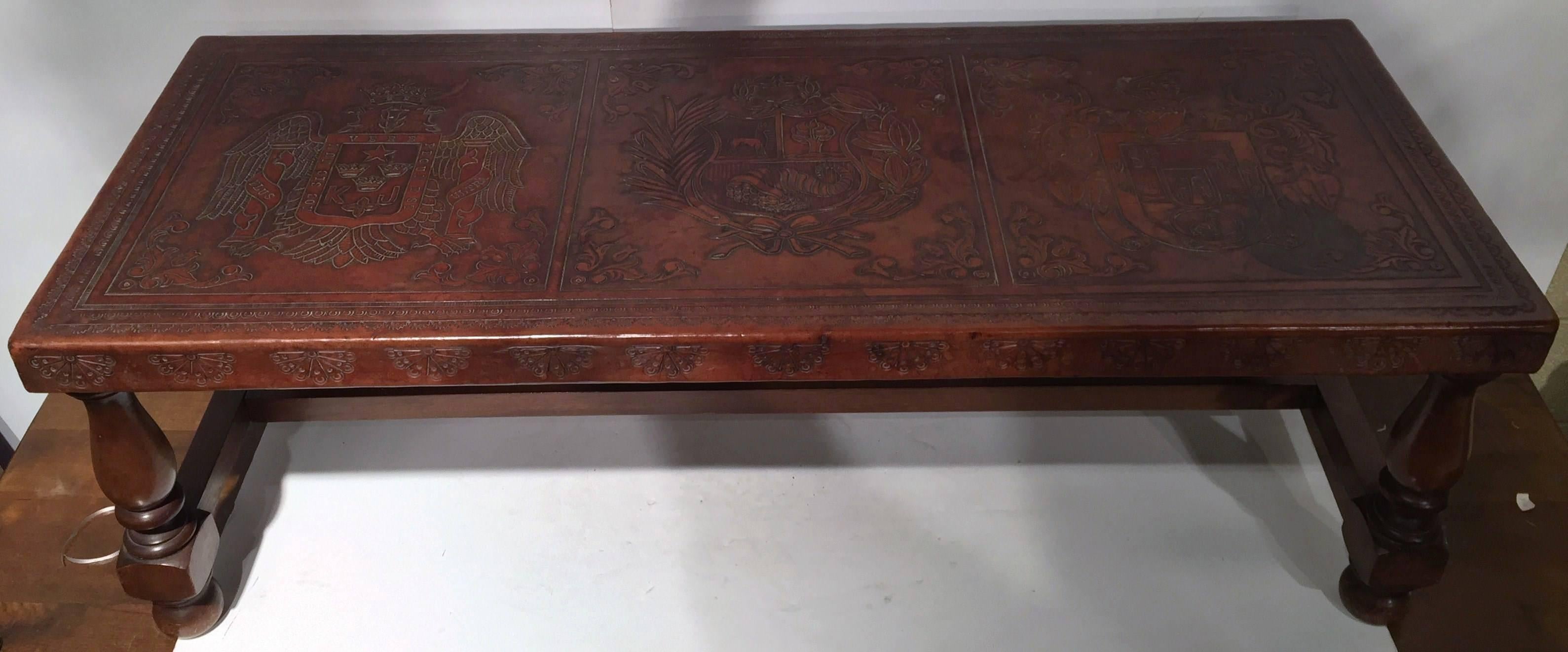 Interesting 19th century walnut bench coffee table from Southern France, circa 1880, featuring tool leather top and 3 embossed coat of arms from 3 different families. Beautiful condition and patina. 