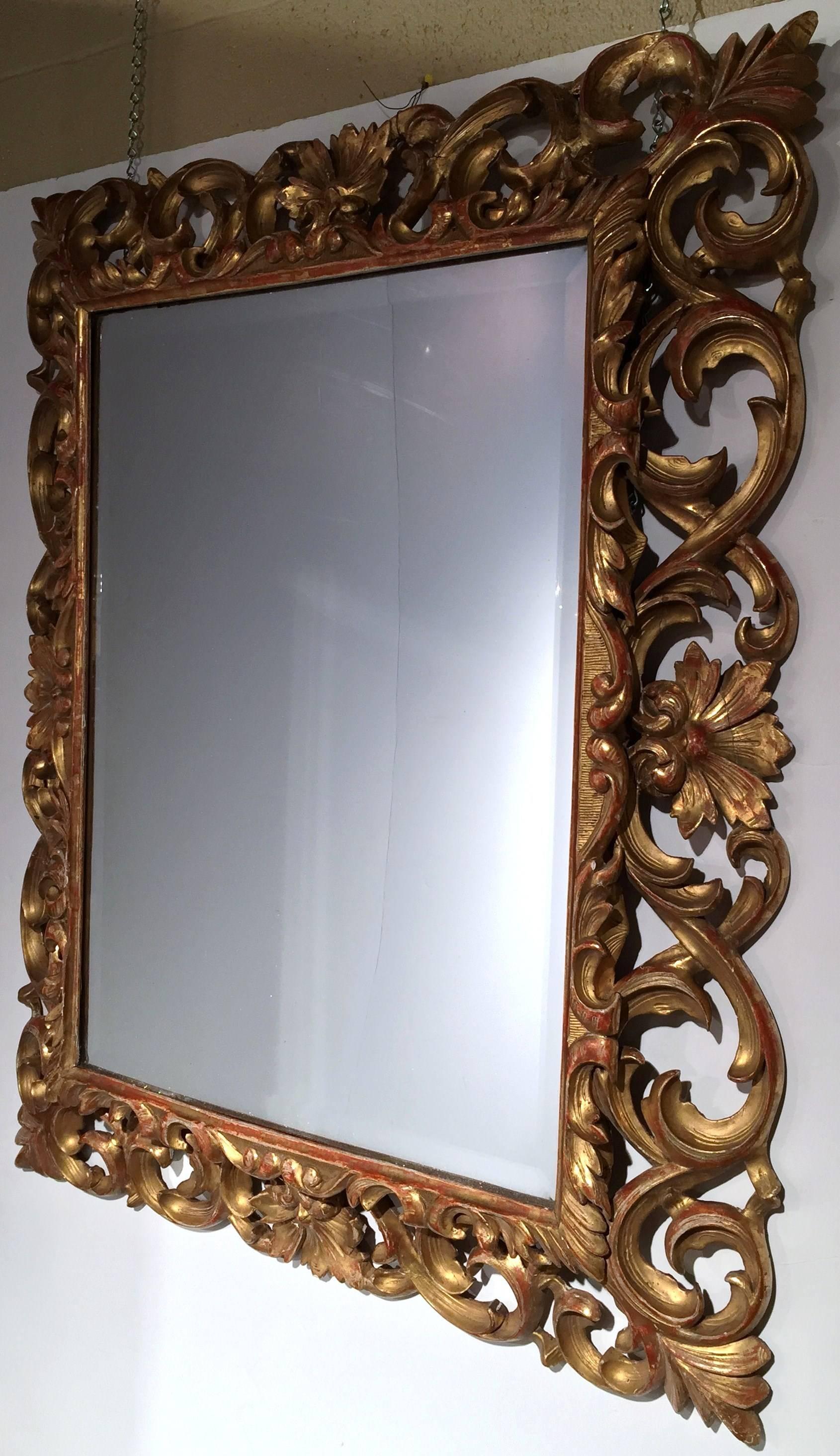 Incorporate Classic French elegance into your home with this antique, ornate mirror. Crafted in France, circa 1860, the rectangular mirror has a wood frame adorning a rich gold leaf finish. The frame has a beautiful scroll design embellished with