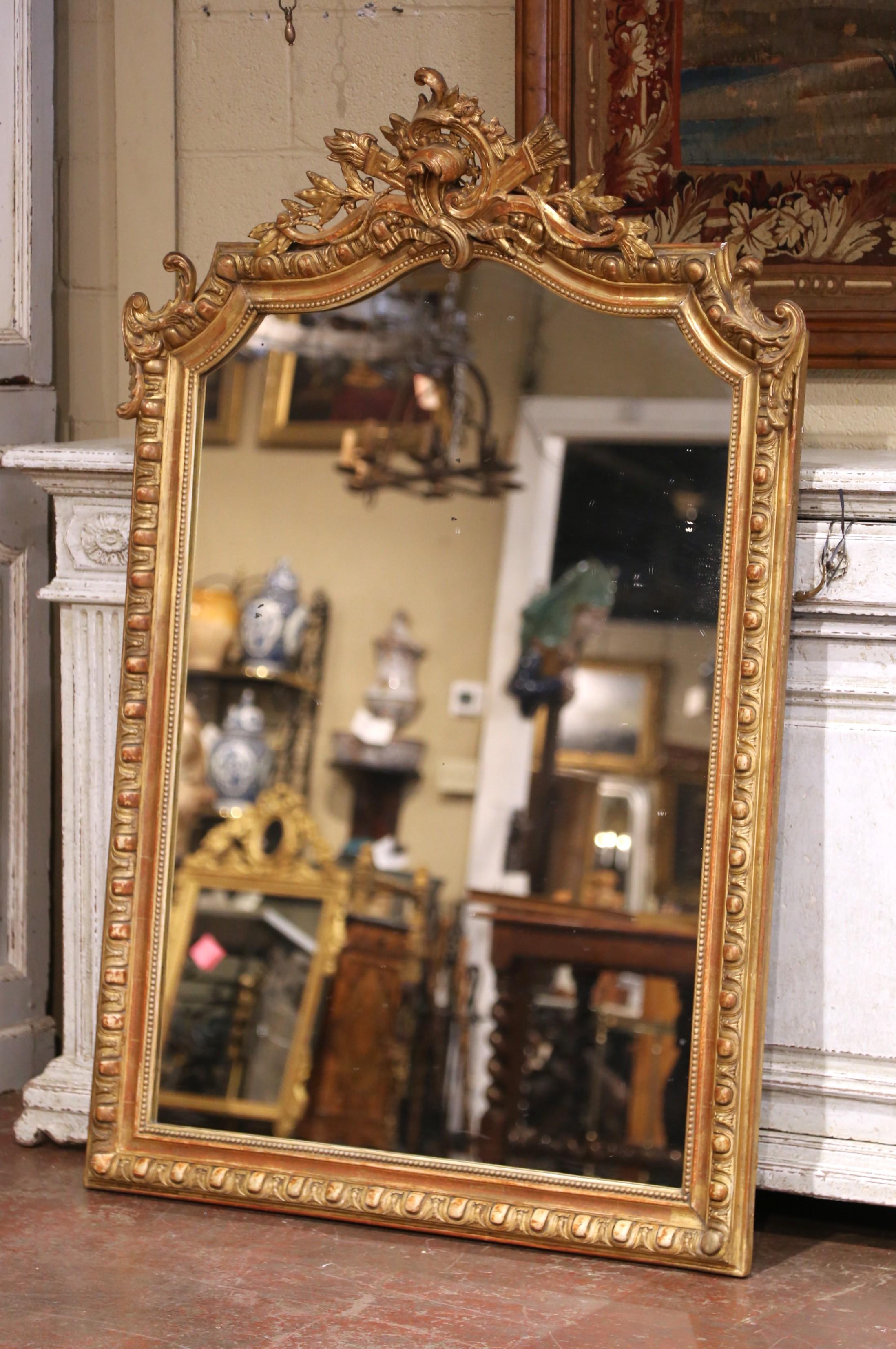 Con casi metro y medio de altura, este importante espejo antiguo de madera dorada es una declaración decorativa única. Fabricado en París, Francia, hacia 1870, el alto marco rectangular presenta una parte superior arqueada en forma de serpiente,