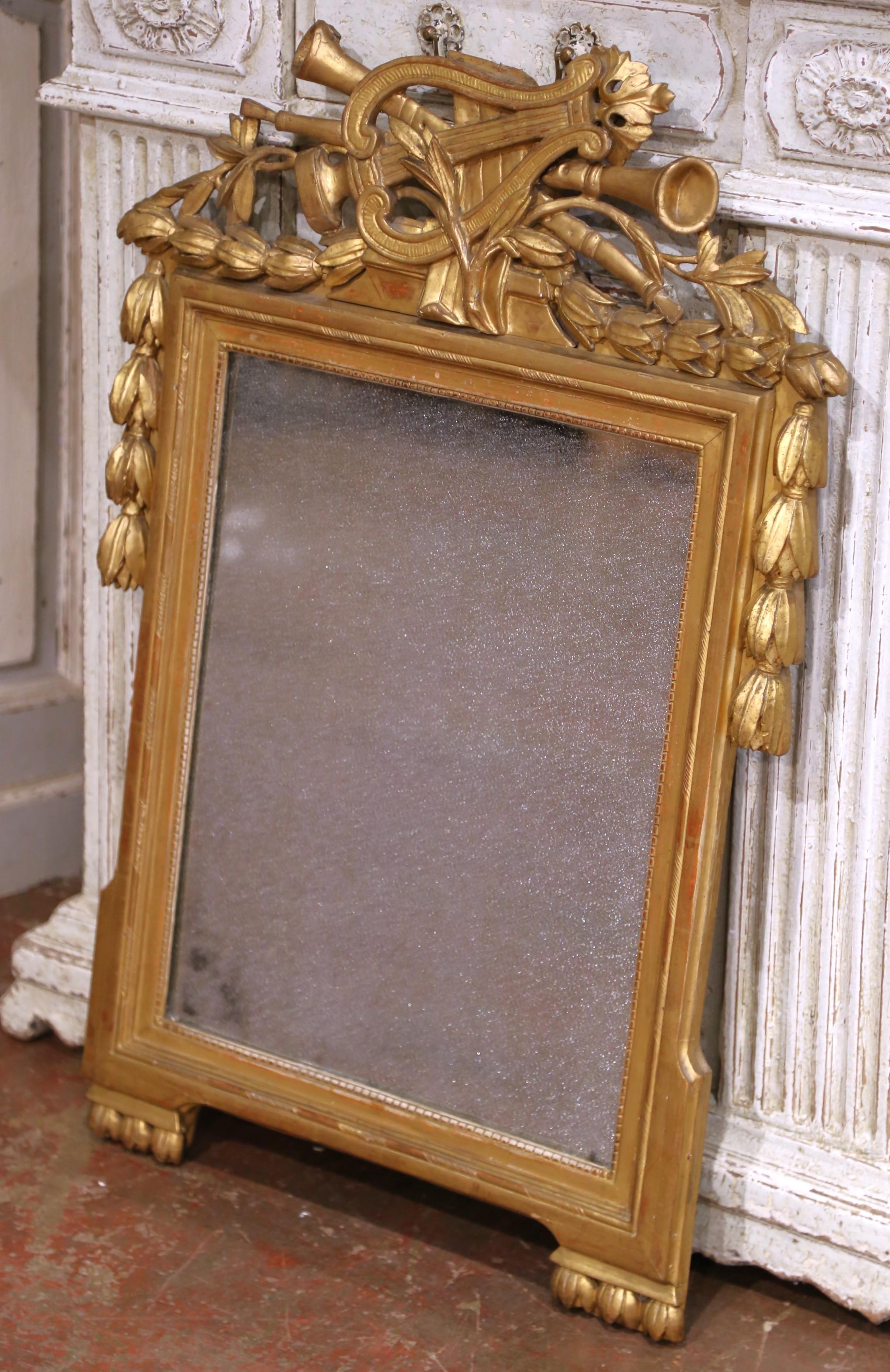 
Apportez une touche d'antiquité raffinée à votre intérieur avec ce miroir en bois doré magnifiquement sculpté, originaire de Provence, France. Fabriqué en Provence, en France, vers 1780, le cadre rectangulaire est couronné d'un écusson orné d'une