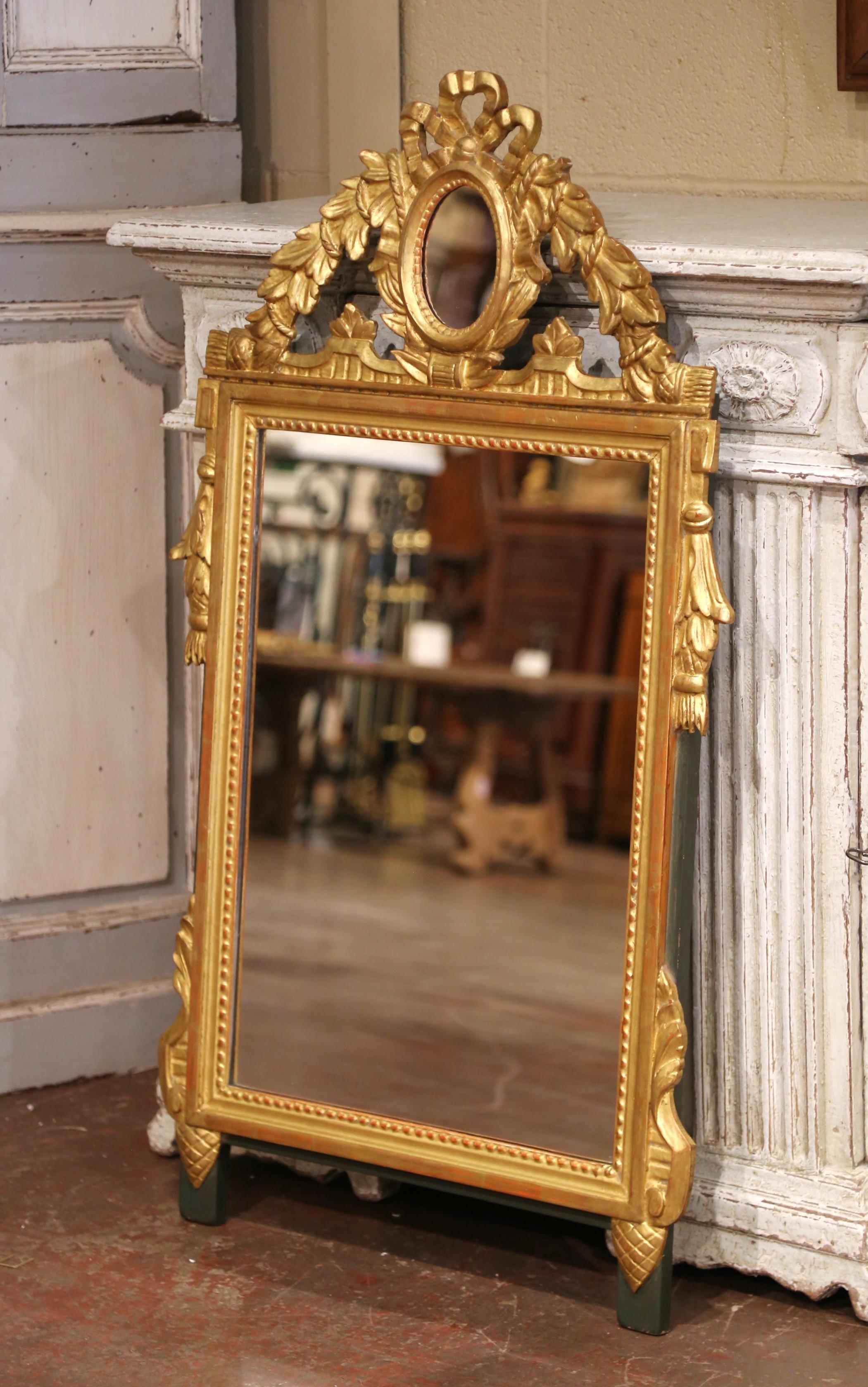 Decora un foyer, un caminetto o una toilette con questo straordinario specchio in legno dorato in stile Luigi XVI. Realizzato in Francia intorno al 1870, lo specchio ha una forma rettangolare sormontata da una cresta scultorea, riccamente intagliata