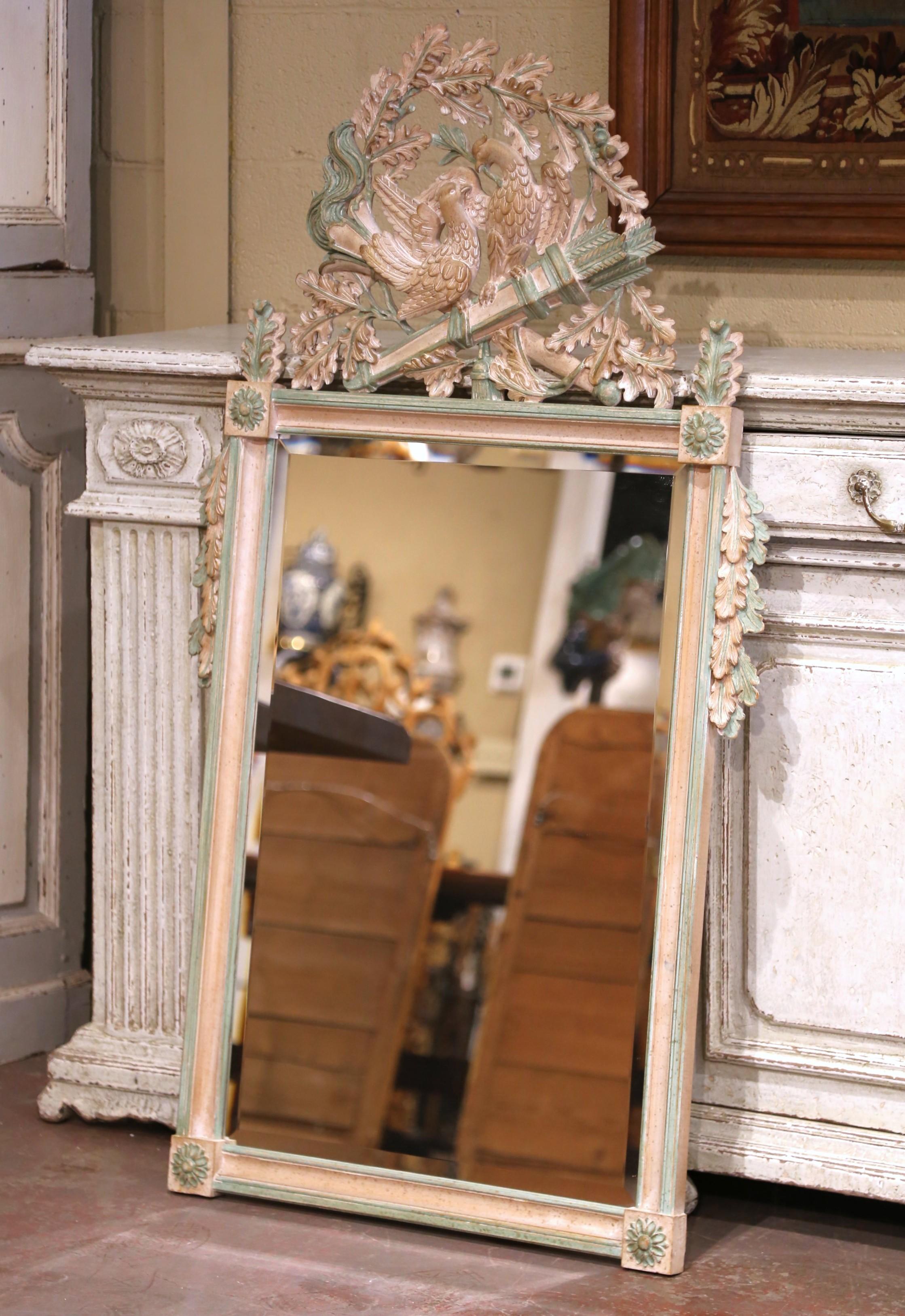 Decora un recibidor, un dormitorio o un tocador con este encantador espejo pintado de estilo Luis XVI. Fabricado en Francia hacia 1970, el alto marco rectangular está coronado por una elaborada cresta tallada con un par de palomas posadas entre