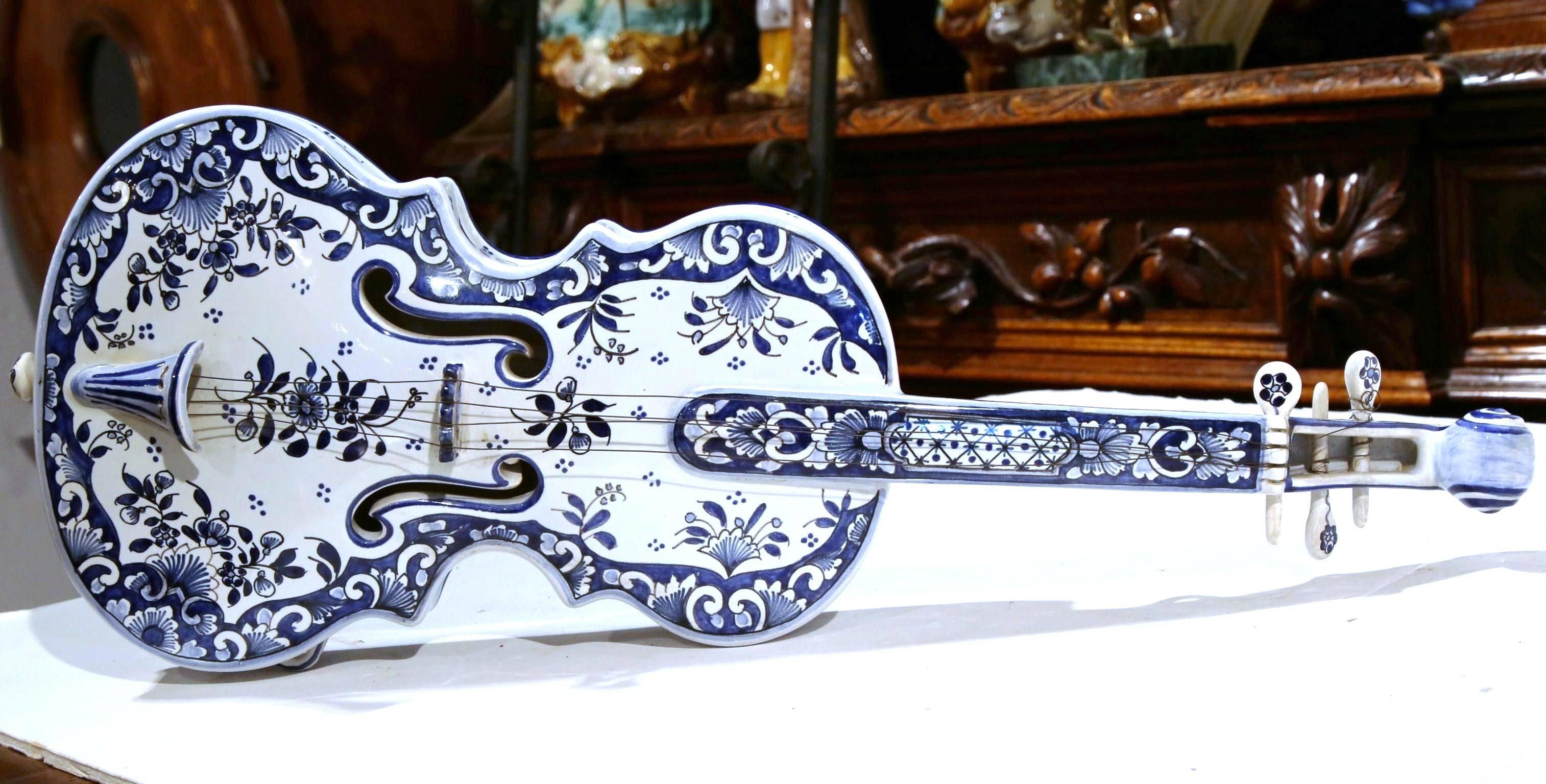 Decorate a wall or a shelf with this elegant antique ceramic violin; crafted in the Normand city of Rouen, France, circa 1920, the colorful faience music instrument features hand painted floral decor in the traditional Delft blue and white palette.