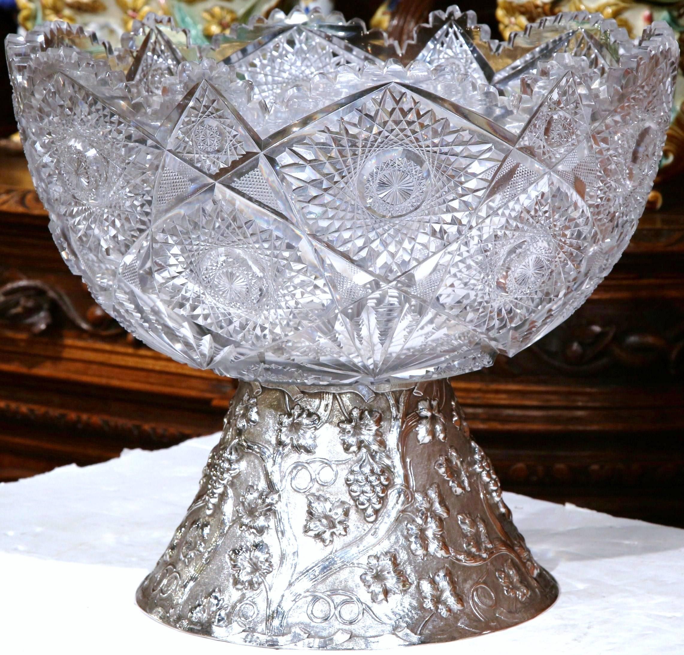 This elegant cut-glass punch bowl and separate silver repoussé base was crafted in France, circa 1890. The antique bar essential features a round cut-glass bowl with a scalloped edge sited on an intricate base with repoussé wine decor including
